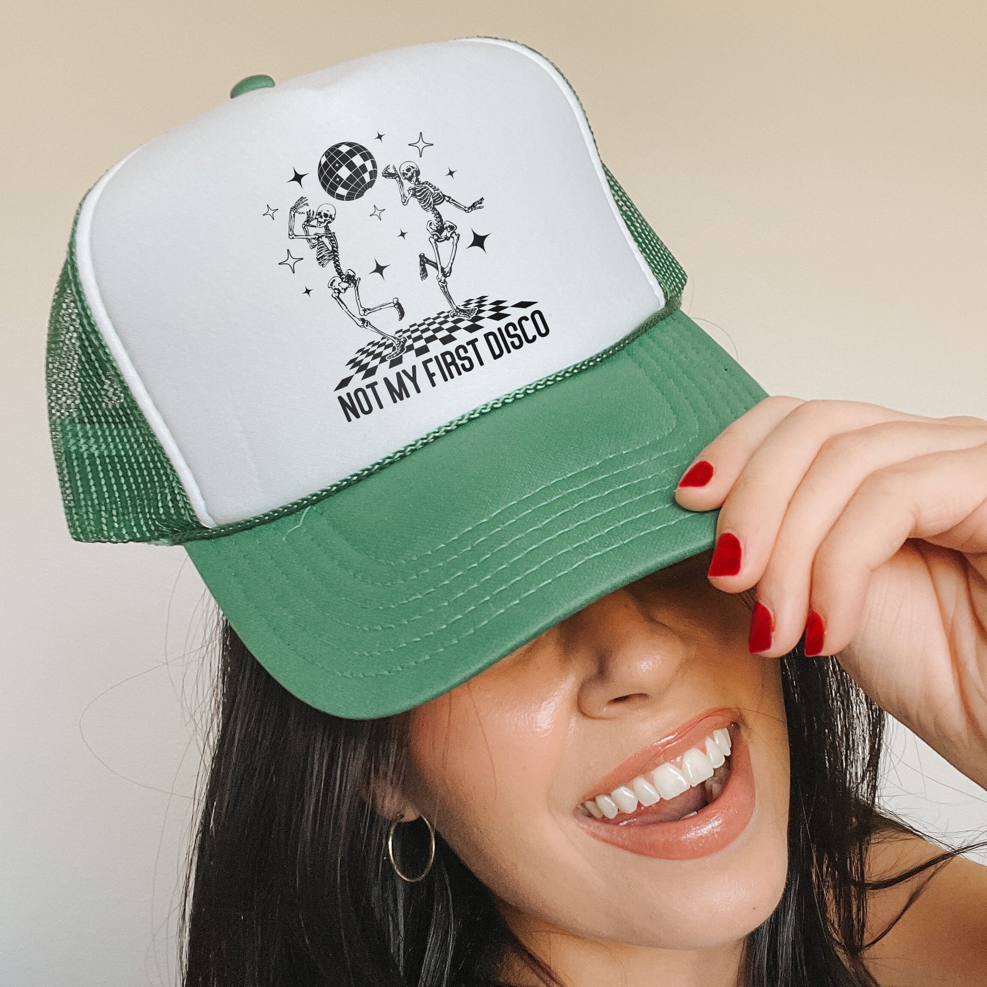 a woman wearing a green and white trucker hat