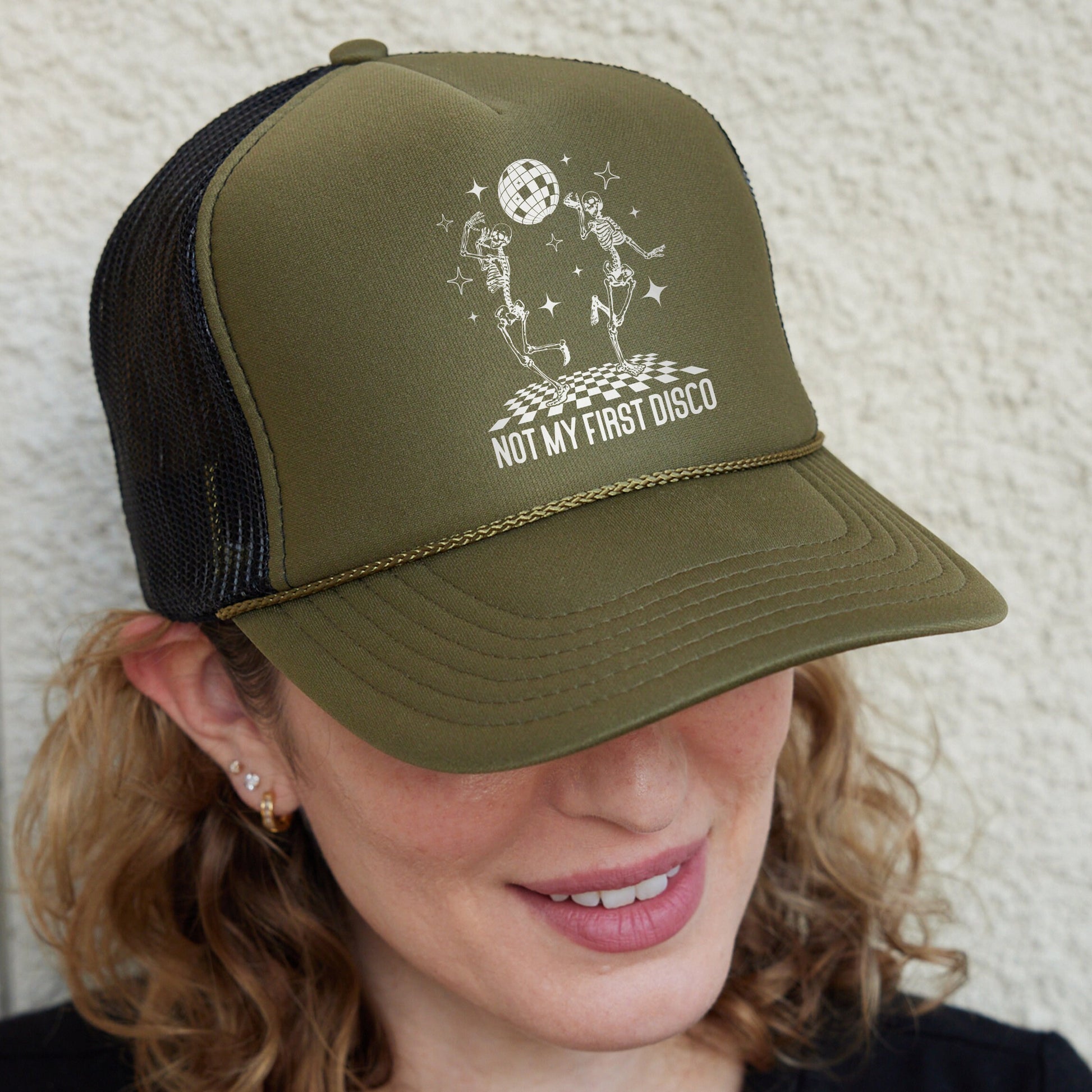 a woman wearing a green hat with a picture of a man on it