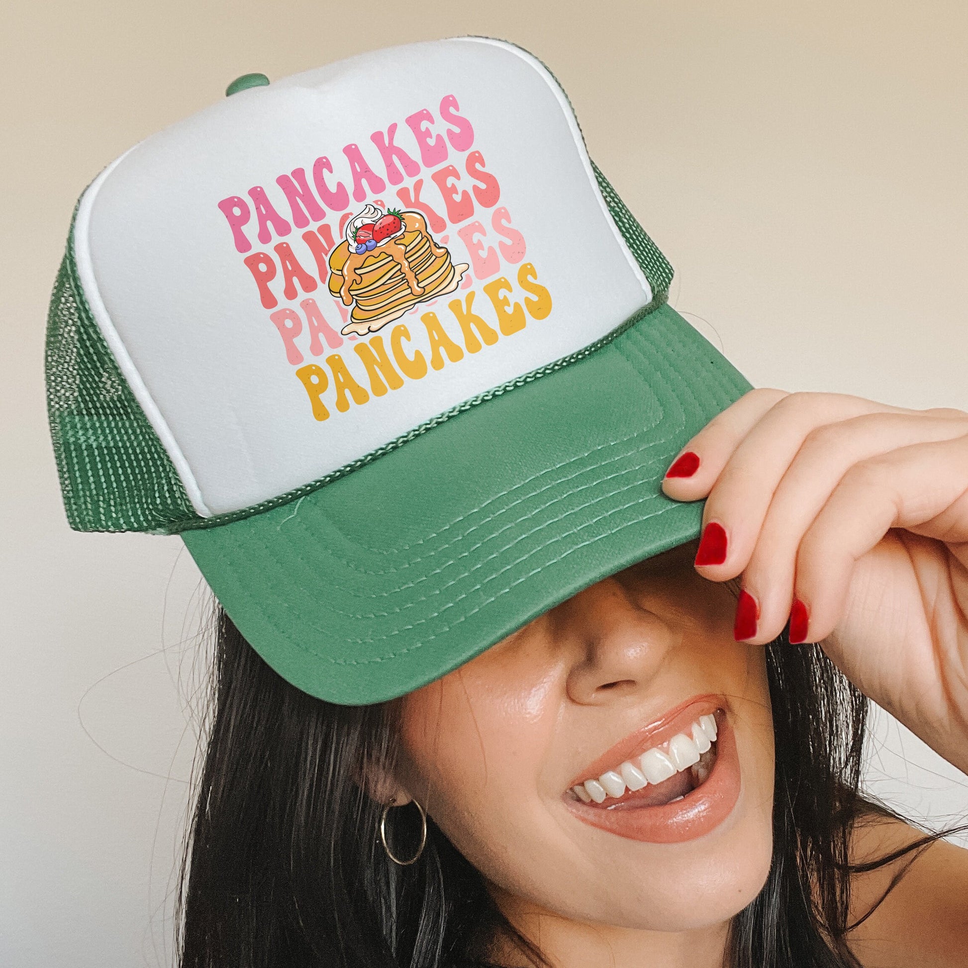 a woman wearing a green and white trucker hat