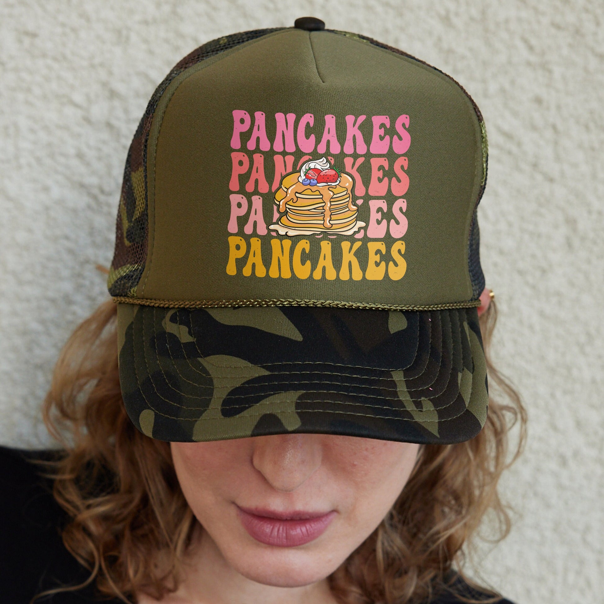 a woman wearing a camouflage hat with pancakes on it