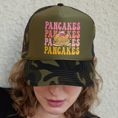 a woman wearing a camouflage hat with pancakes on it