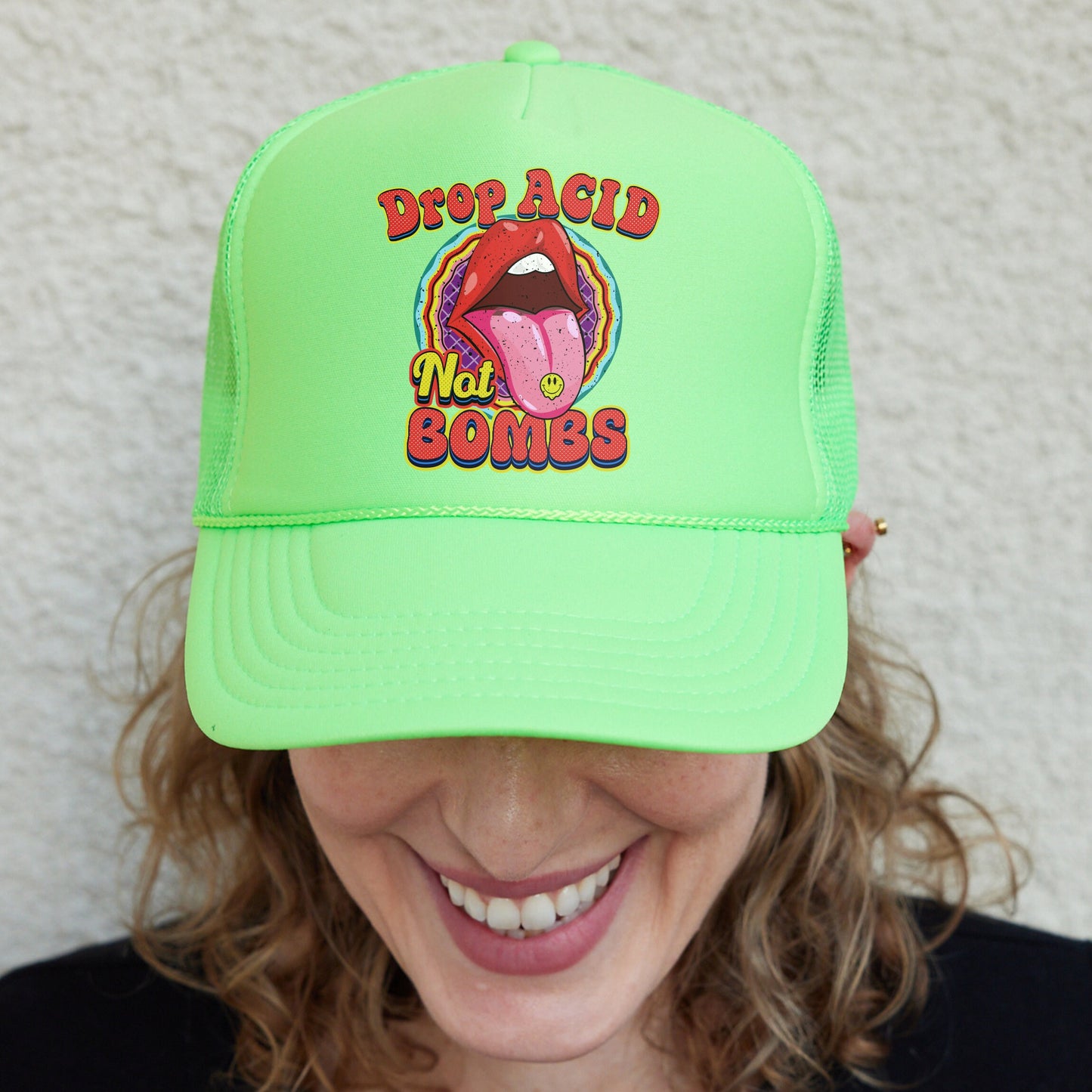 a woman wearing a green hat with a tongue on it