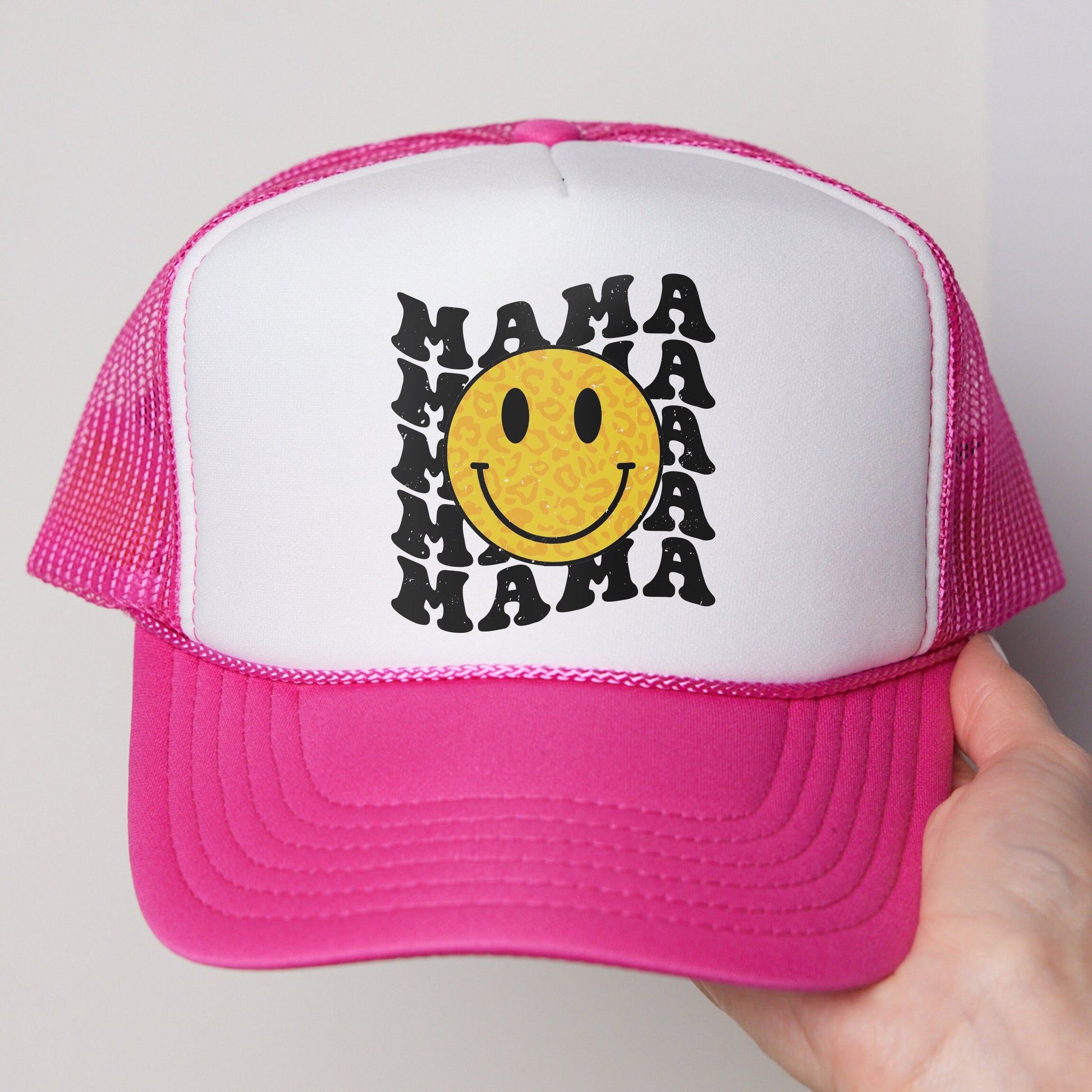 a pink and white trucker hat with a smiley face