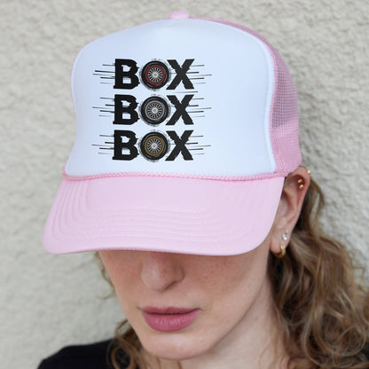 a woman wearing a pink and white hat with the words box box on it