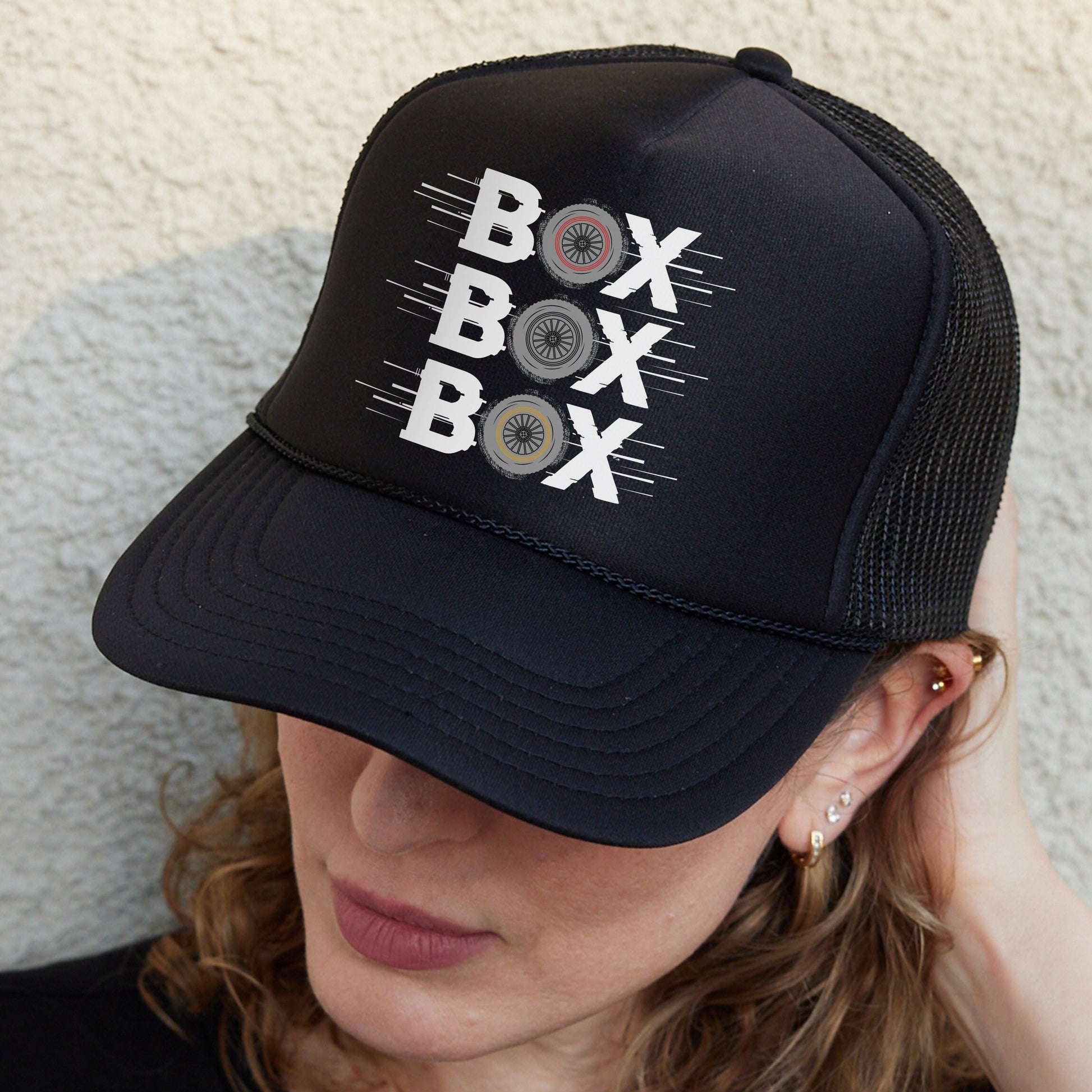 a woman wearing a black hat with the words box box on it