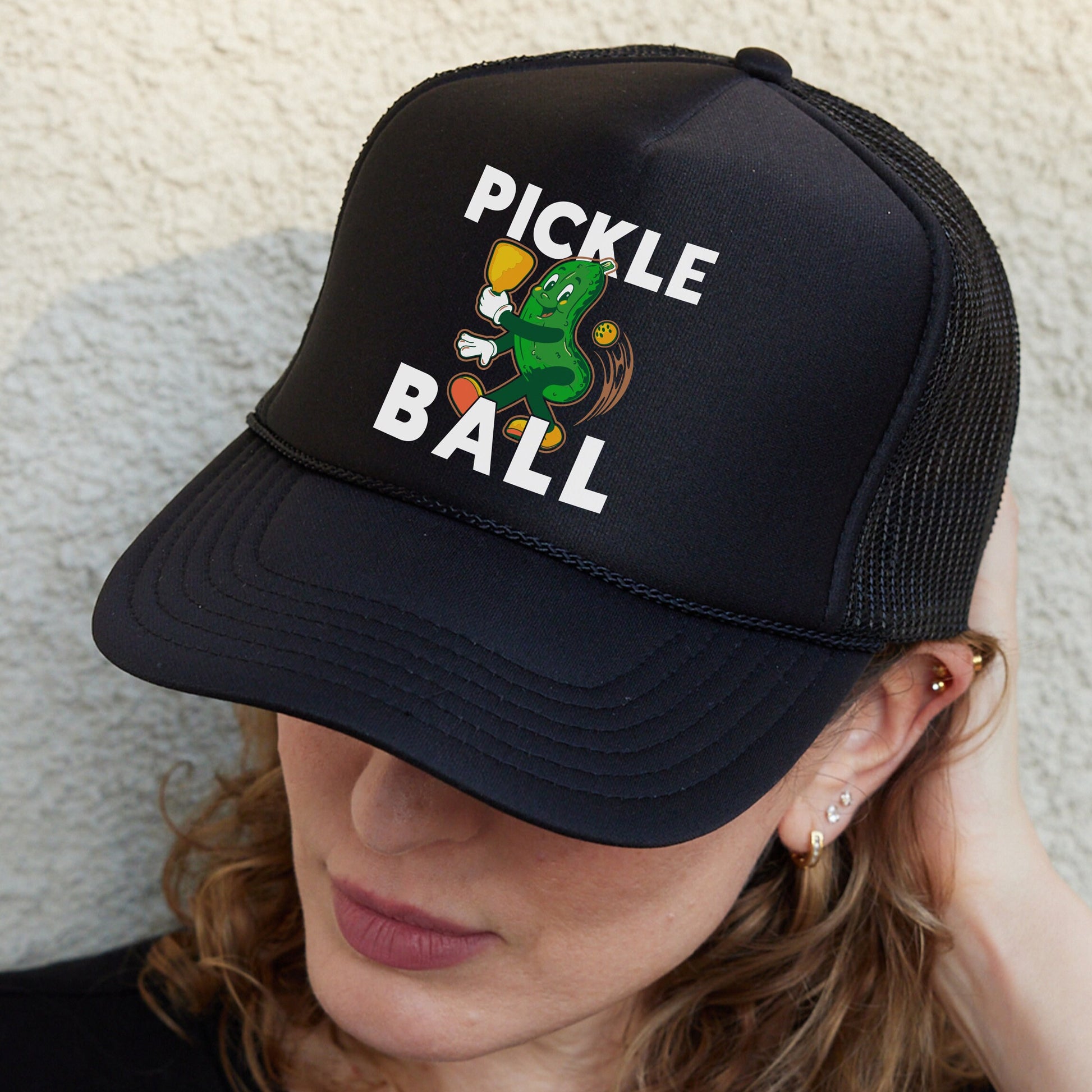 a woman wearing a black pickle ball hat