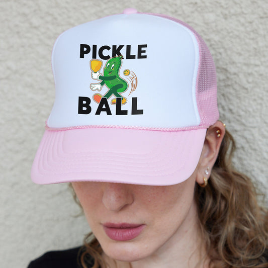 a woman wearing a pink and white pickle ball hat