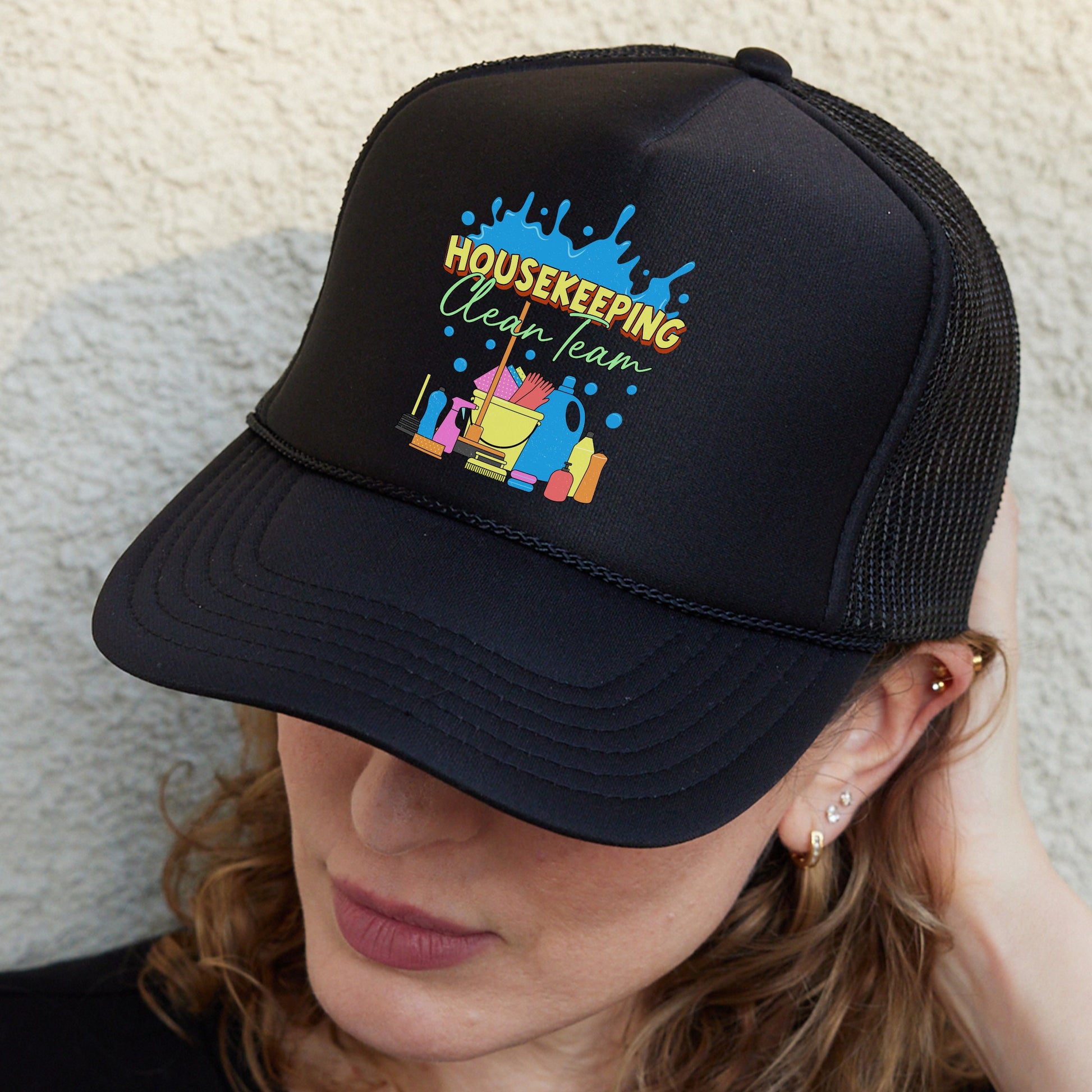 a woman wearing a black trucker hat with the words house keeping on it