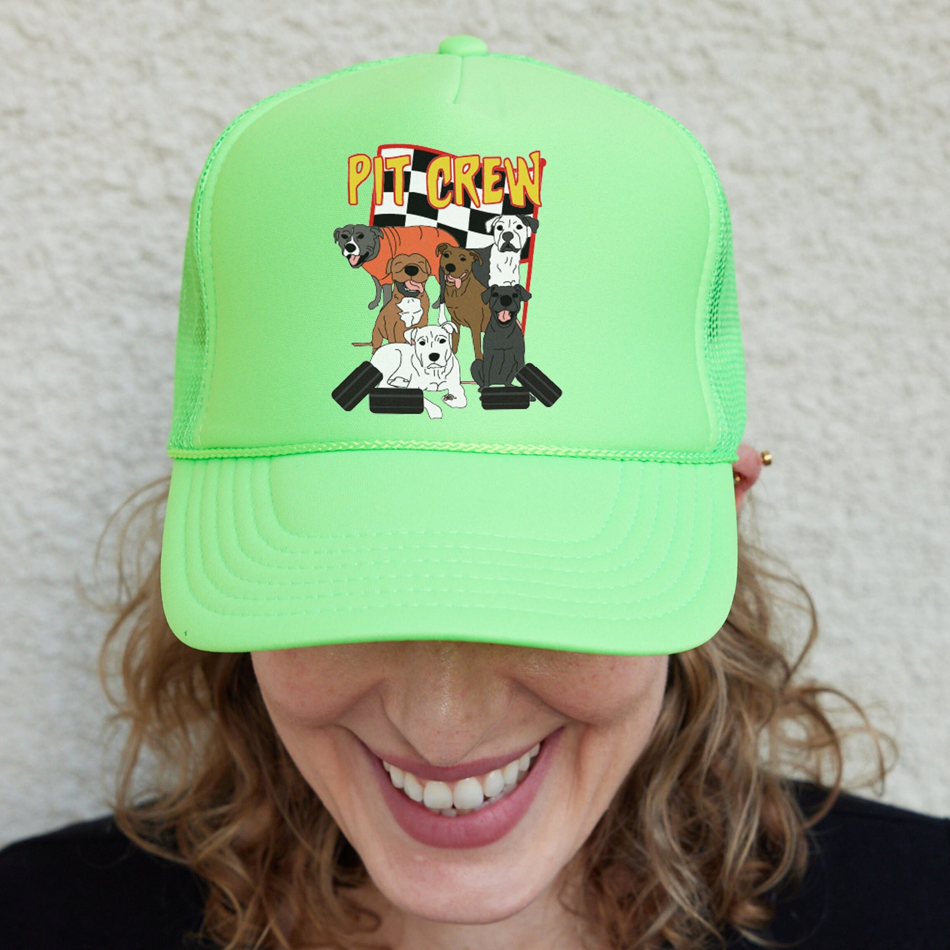 a woman wearing a green trucker hat with dogs on it