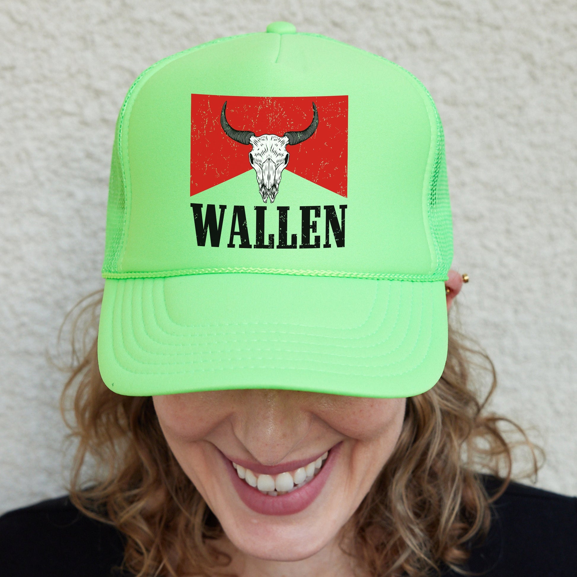 a woman wearing a green hat with a bull&#39;s head on it