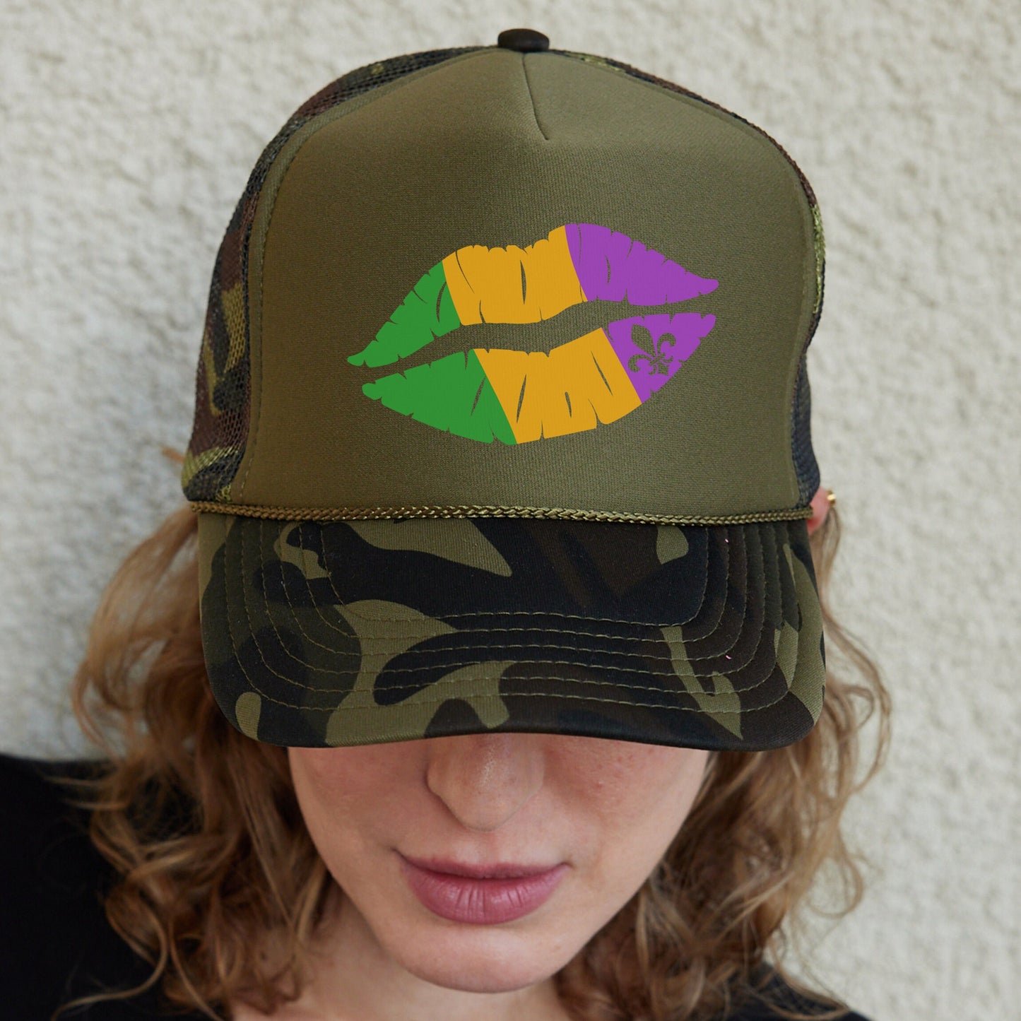 a woman wearing a camo hat with lipstick painted on it