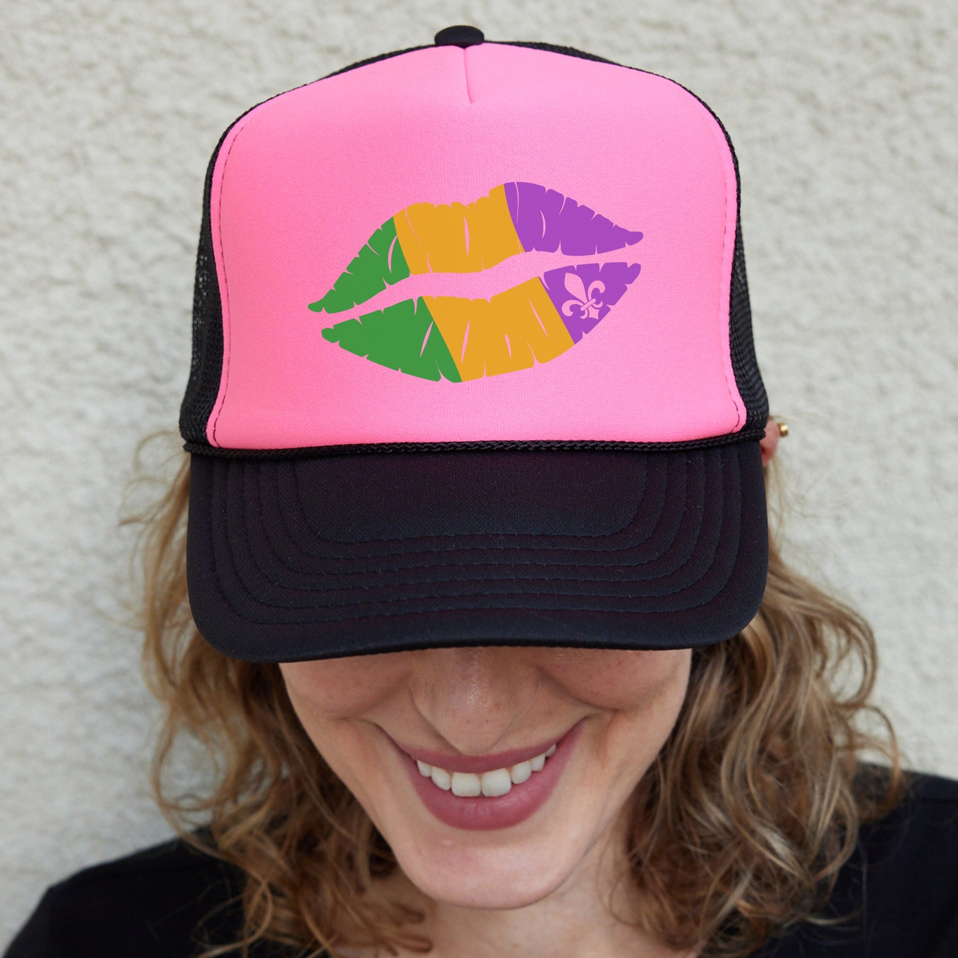 a woman wearing a pink and black hat with colorful lipstick on it