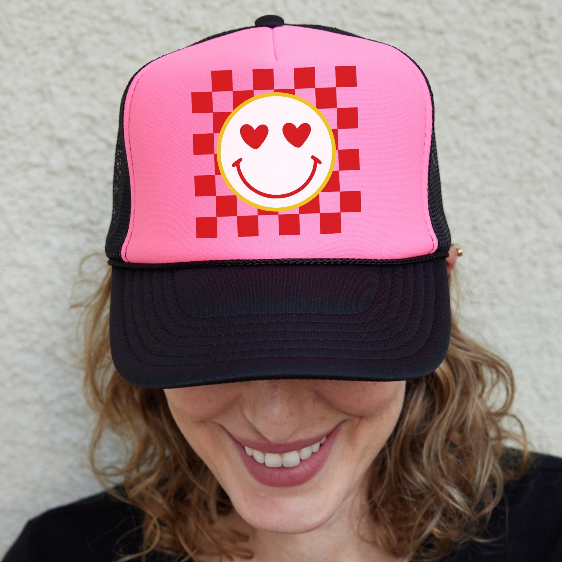 a woman wearing a pink hat with a smiley face on it