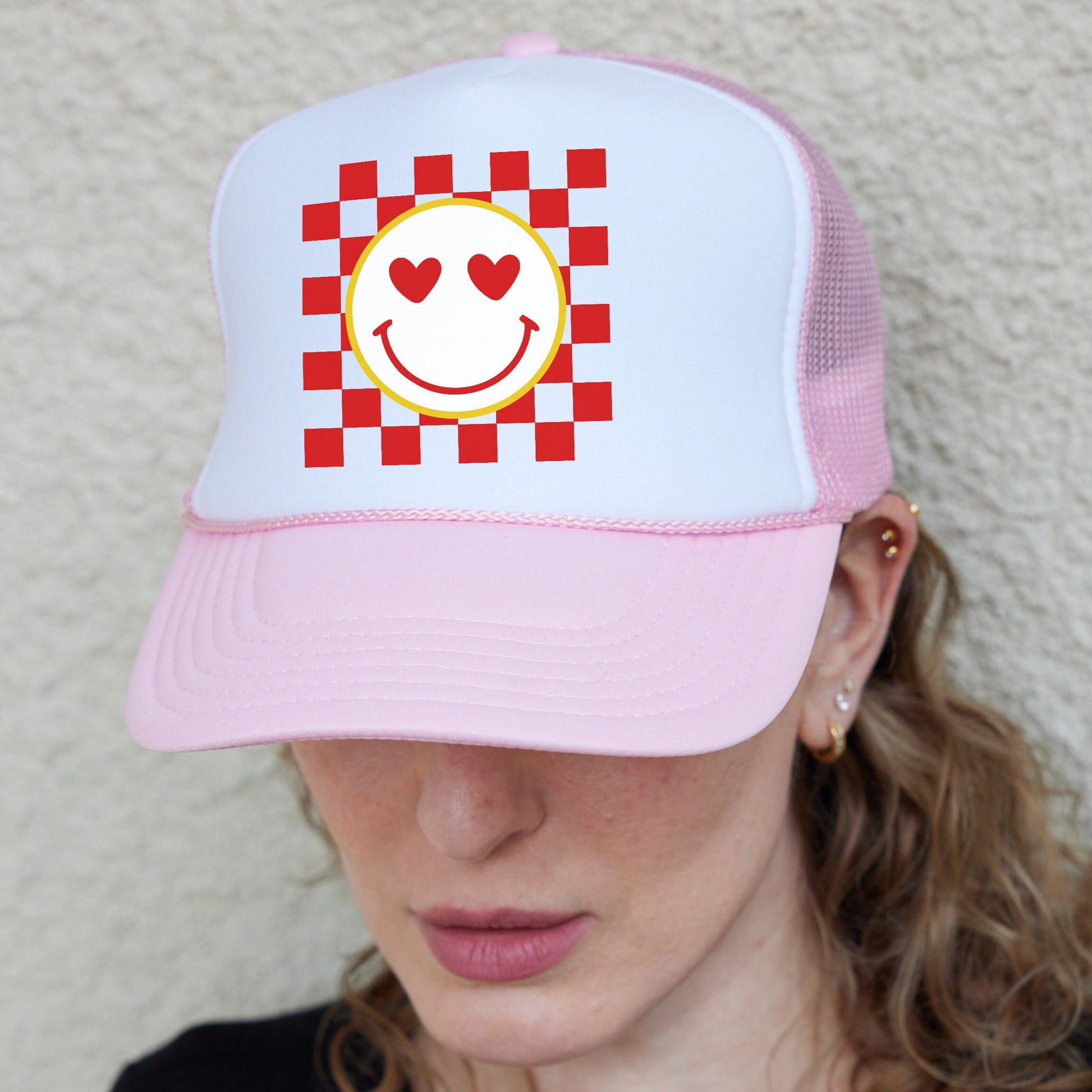 a woman wearing a pink hat with a smiley face on it