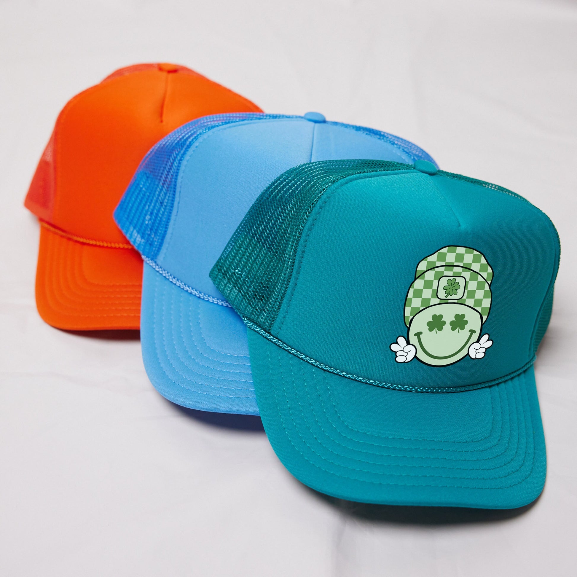 three different colored hats on a white surface