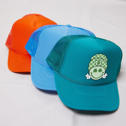 three different colored hats on a white surface