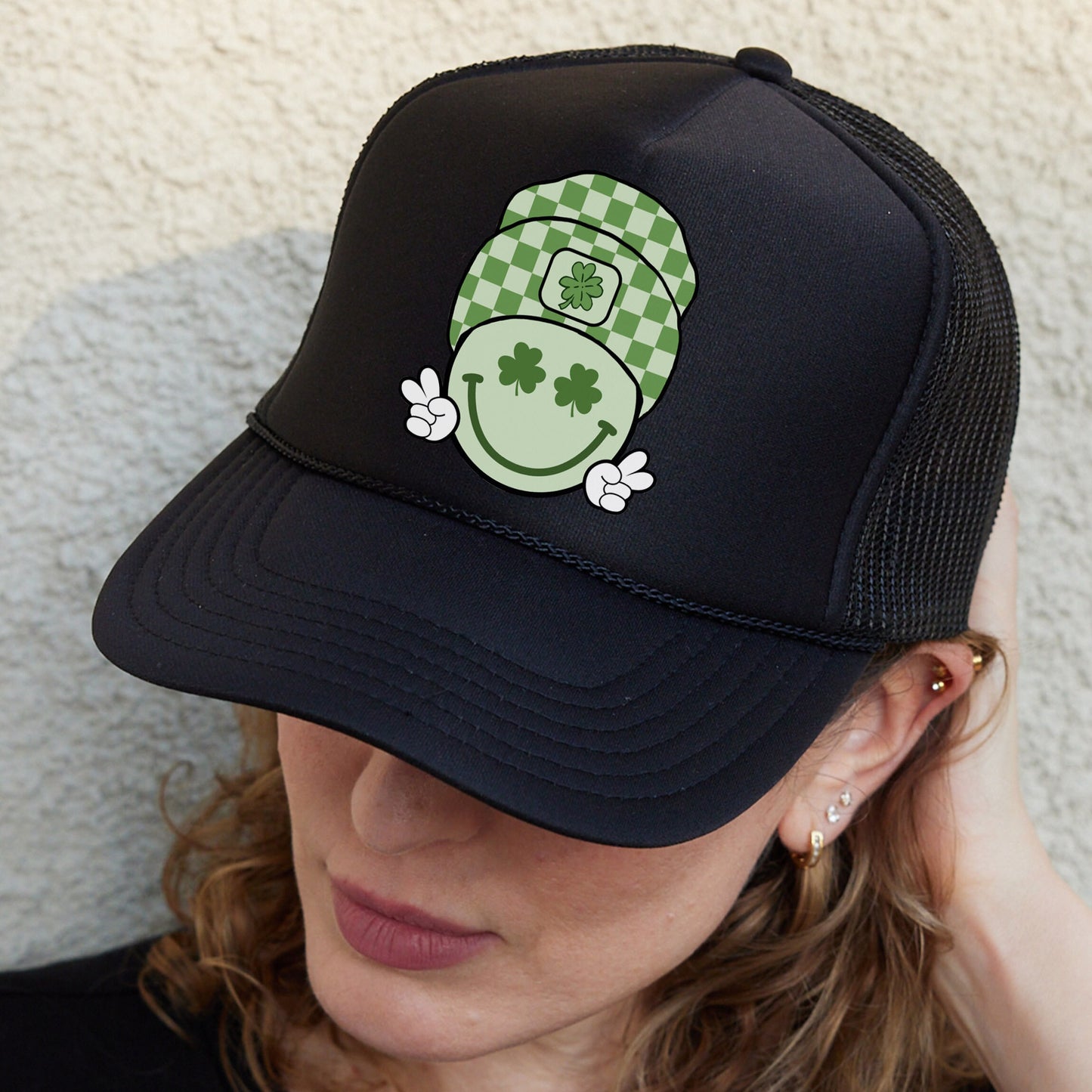 a woman wearing a black hat with a green pot on it