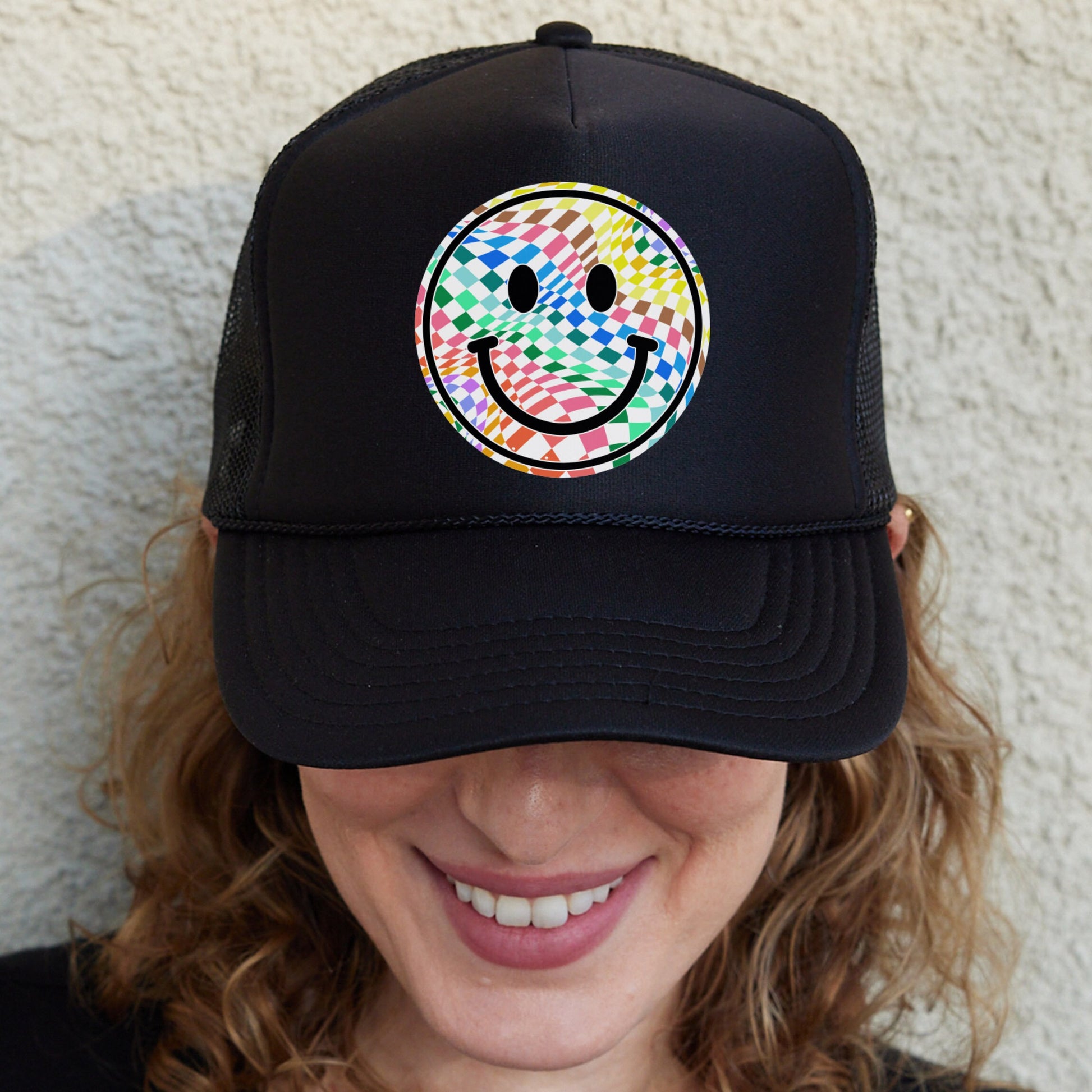 a woman wearing a black hat with a smiley face on it