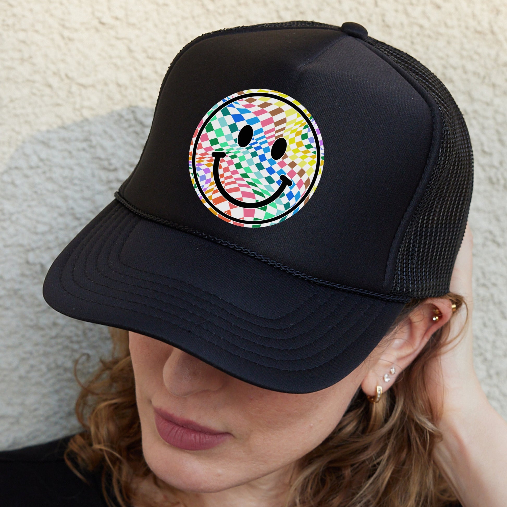 a woman wearing a hat with a smiley face on it
