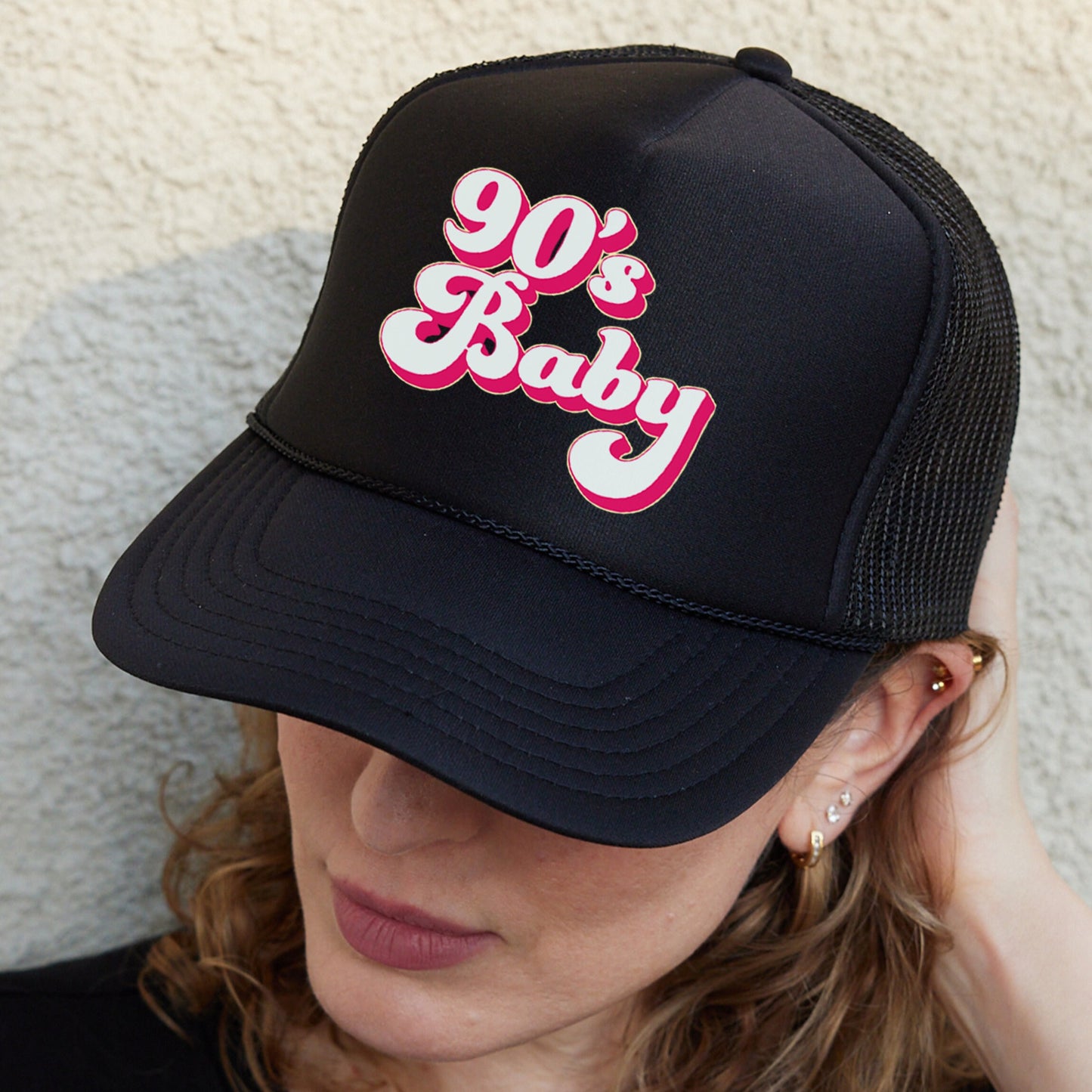 a woman wearing a black hat with the word 90&#39;s baby on it