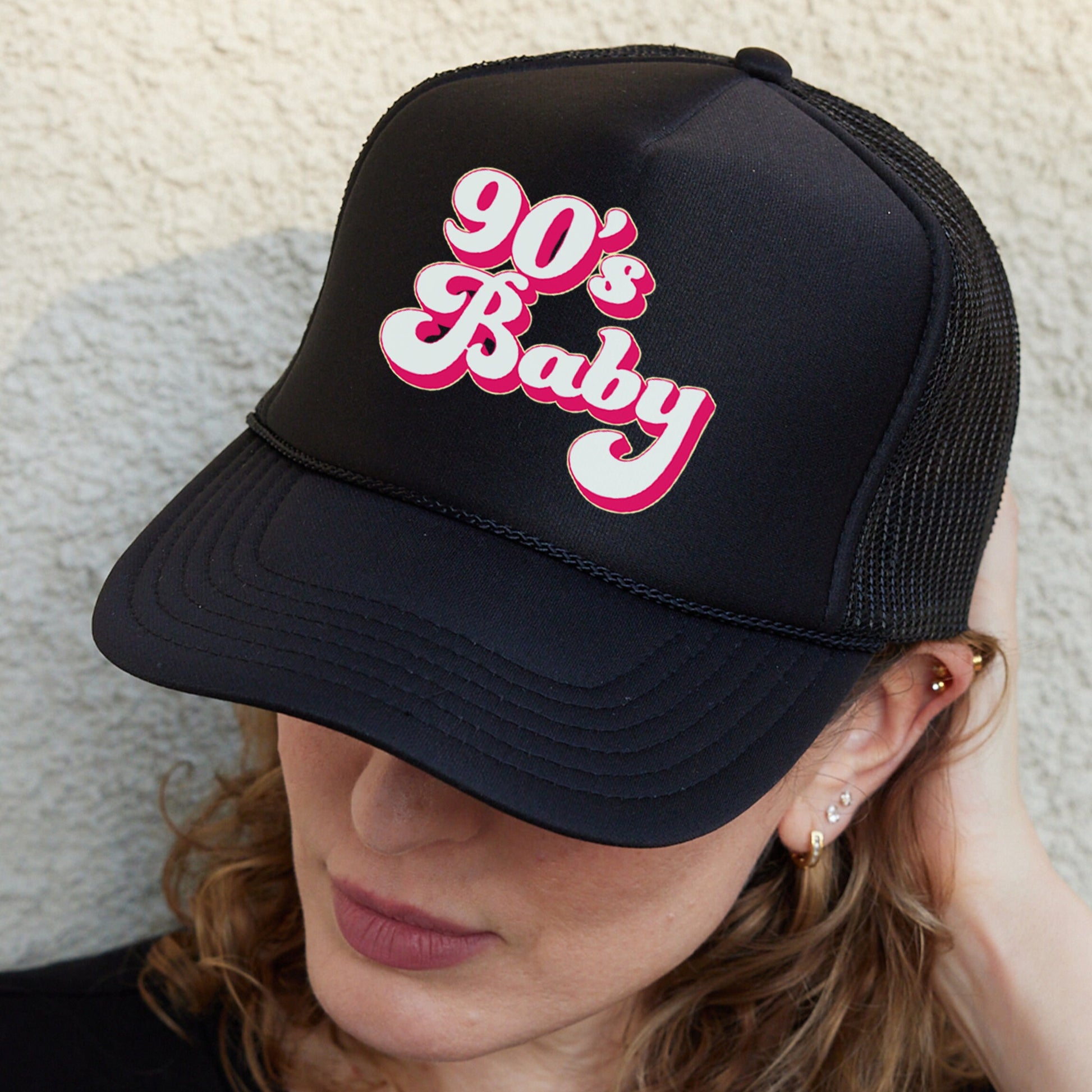 a woman wearing a black hat with the word 90&#39;s baby on it