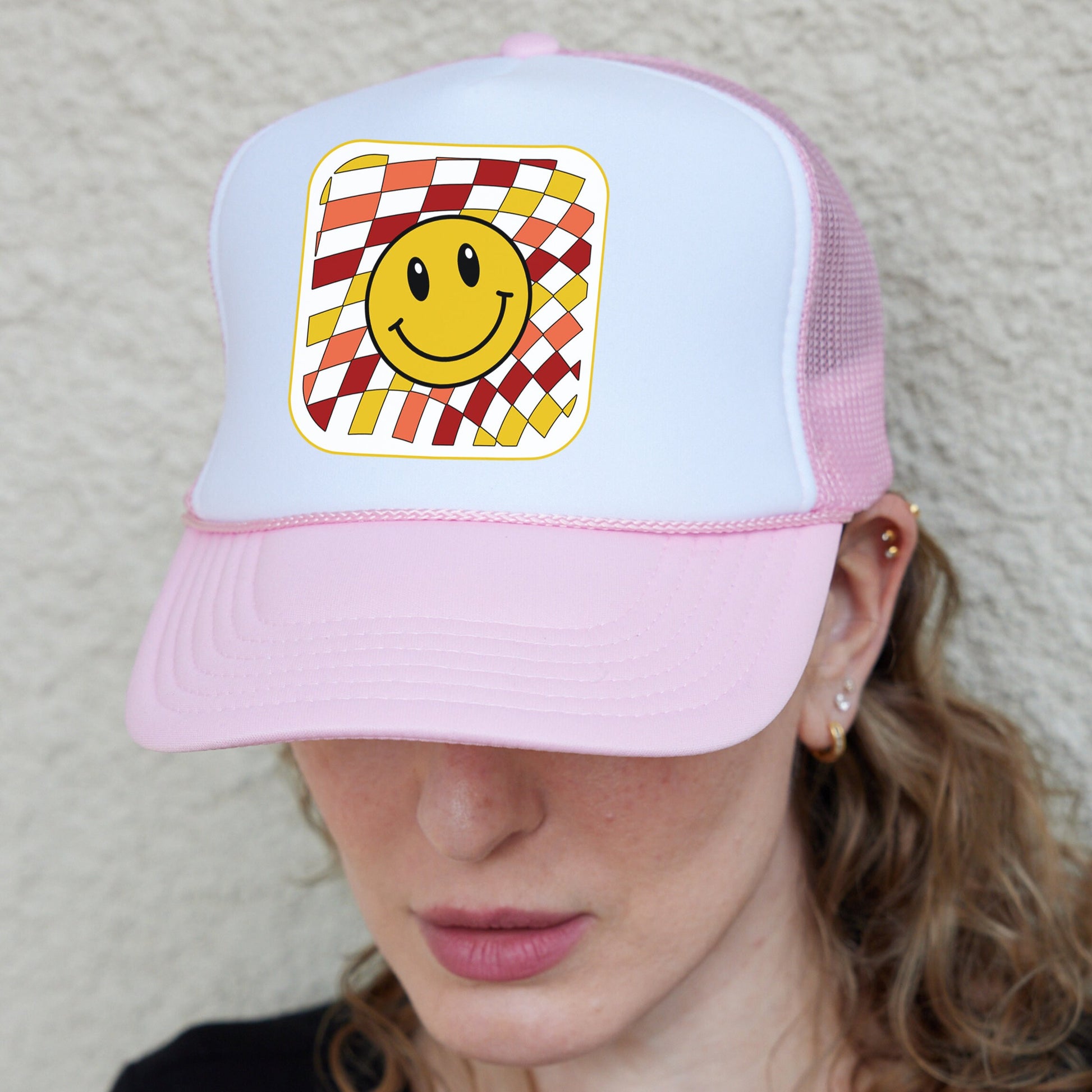 a woman wearing a hat with a smiley face on it