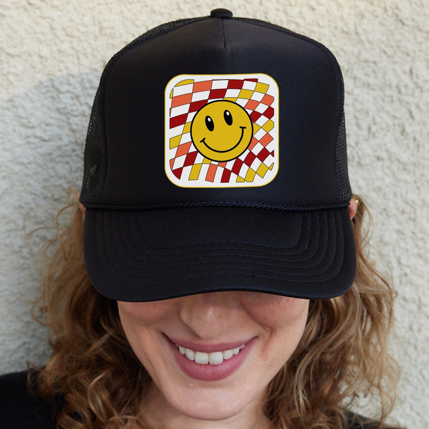 a woman wearing a hat with a smiley face on it