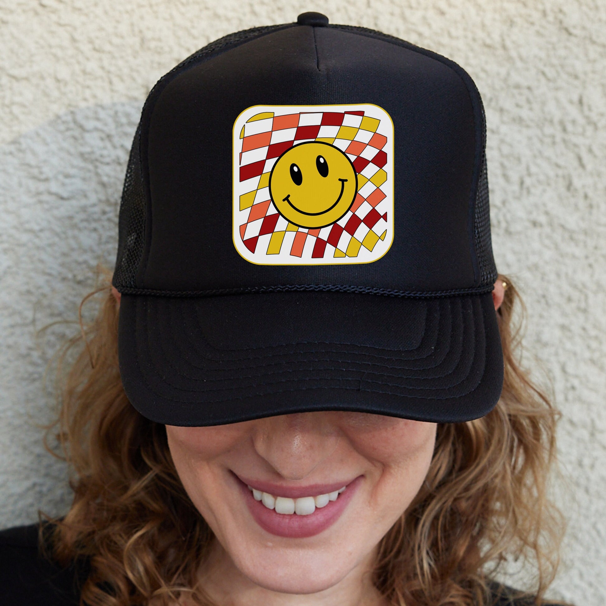 a woman wearing a hat with a smiley face on it