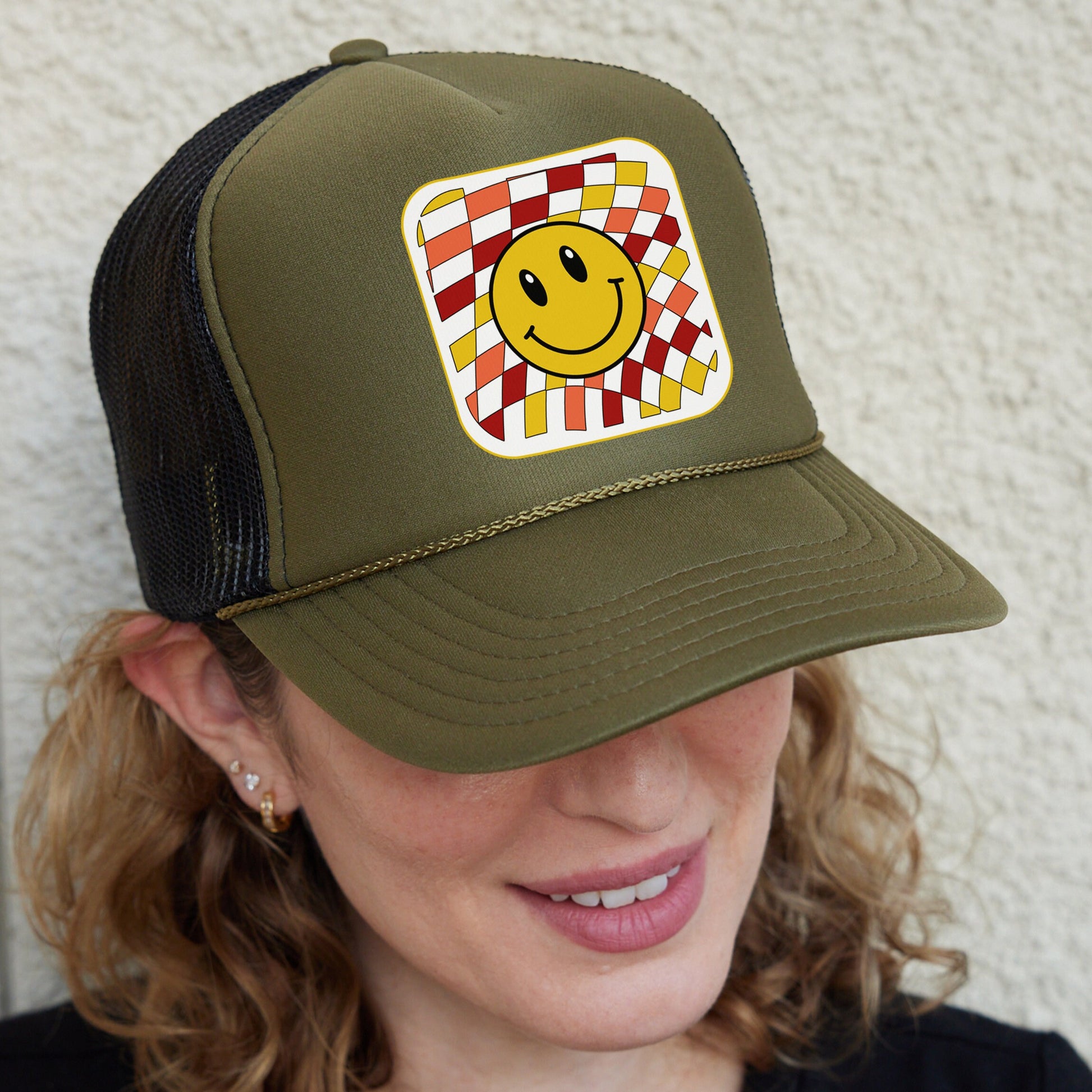 a woman wearing a hat with a smiley face on it