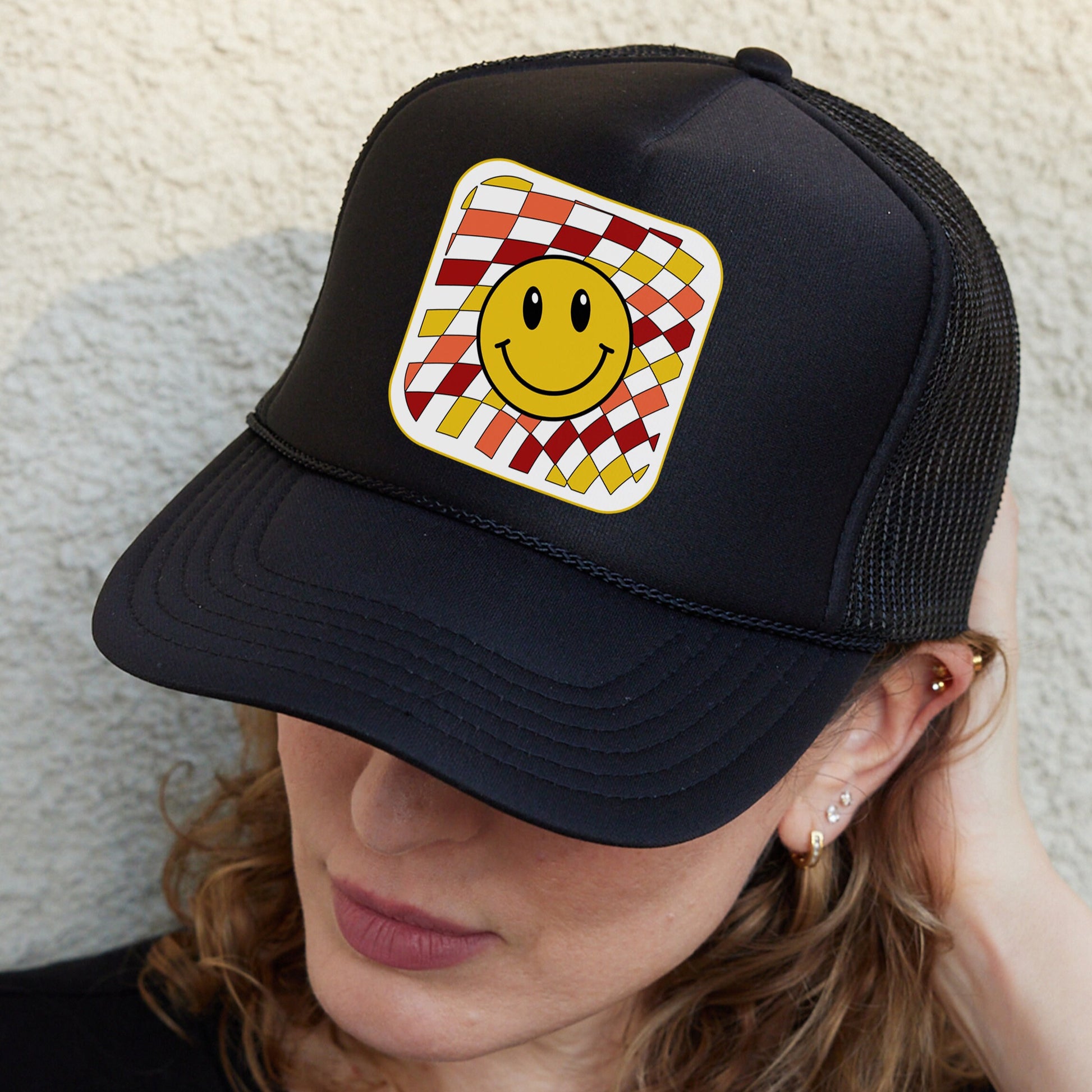 a woman wearing a hat with a smiley face on it