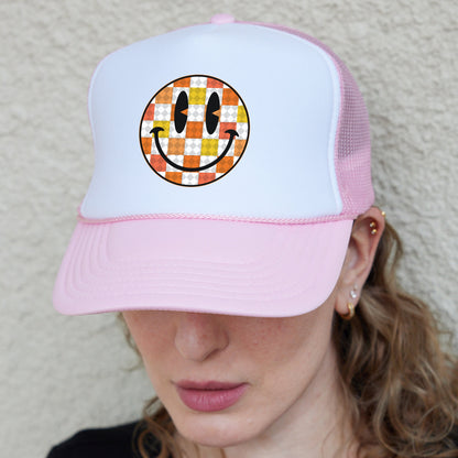 a woman wearing a hat with a smiley face on it