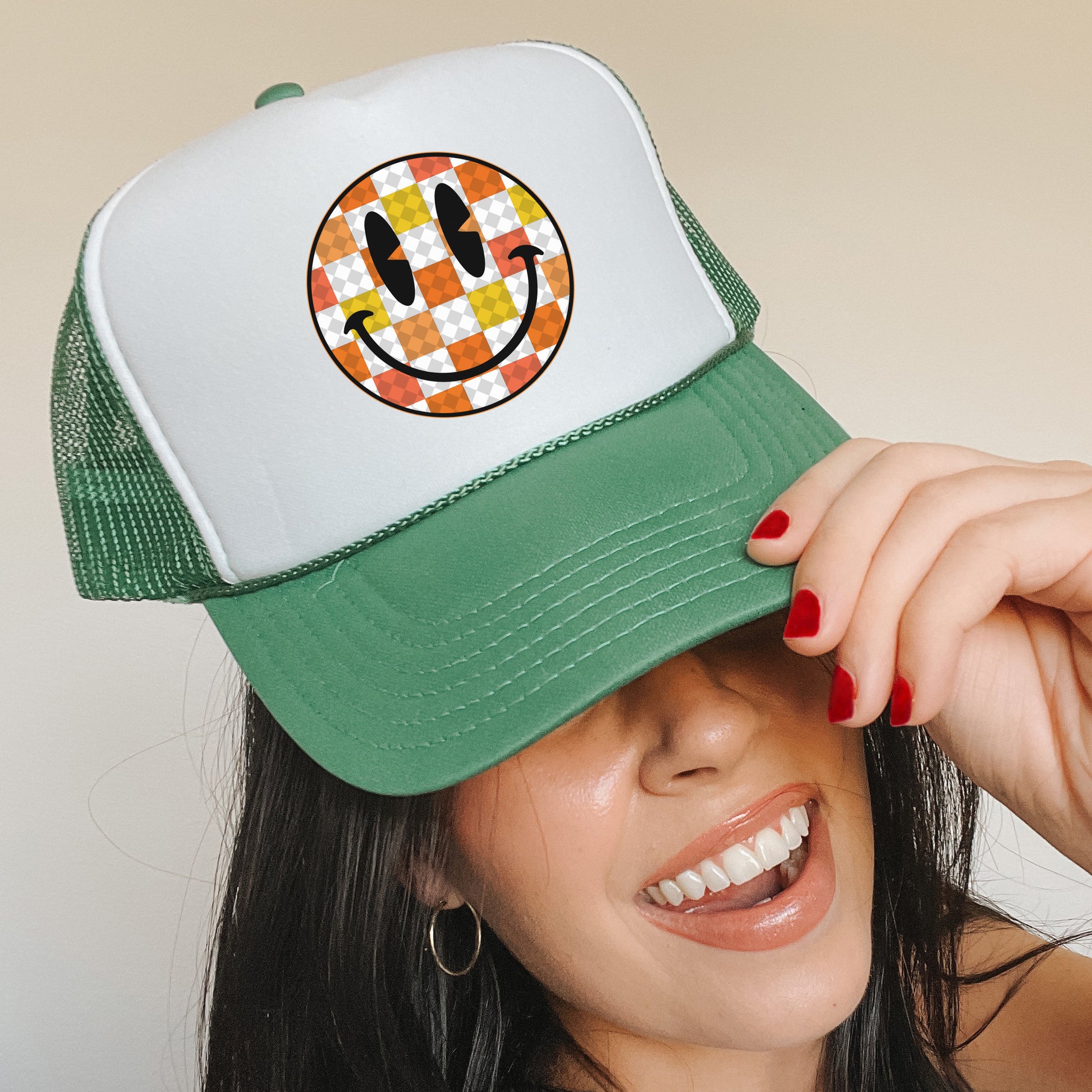 a woman wearing a green and white hat with a smiley face on it