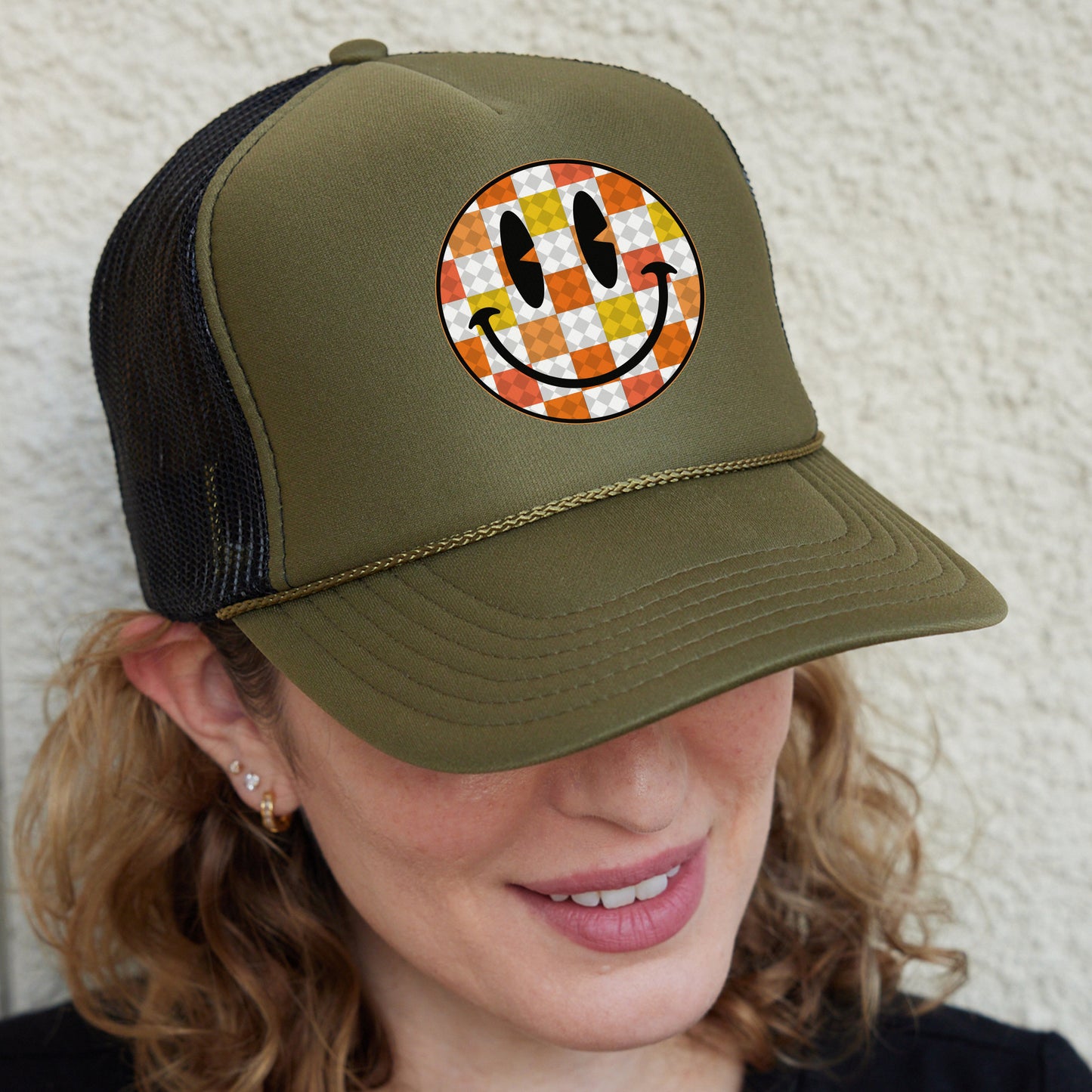 a woman wearing a hat with a smiley face on it