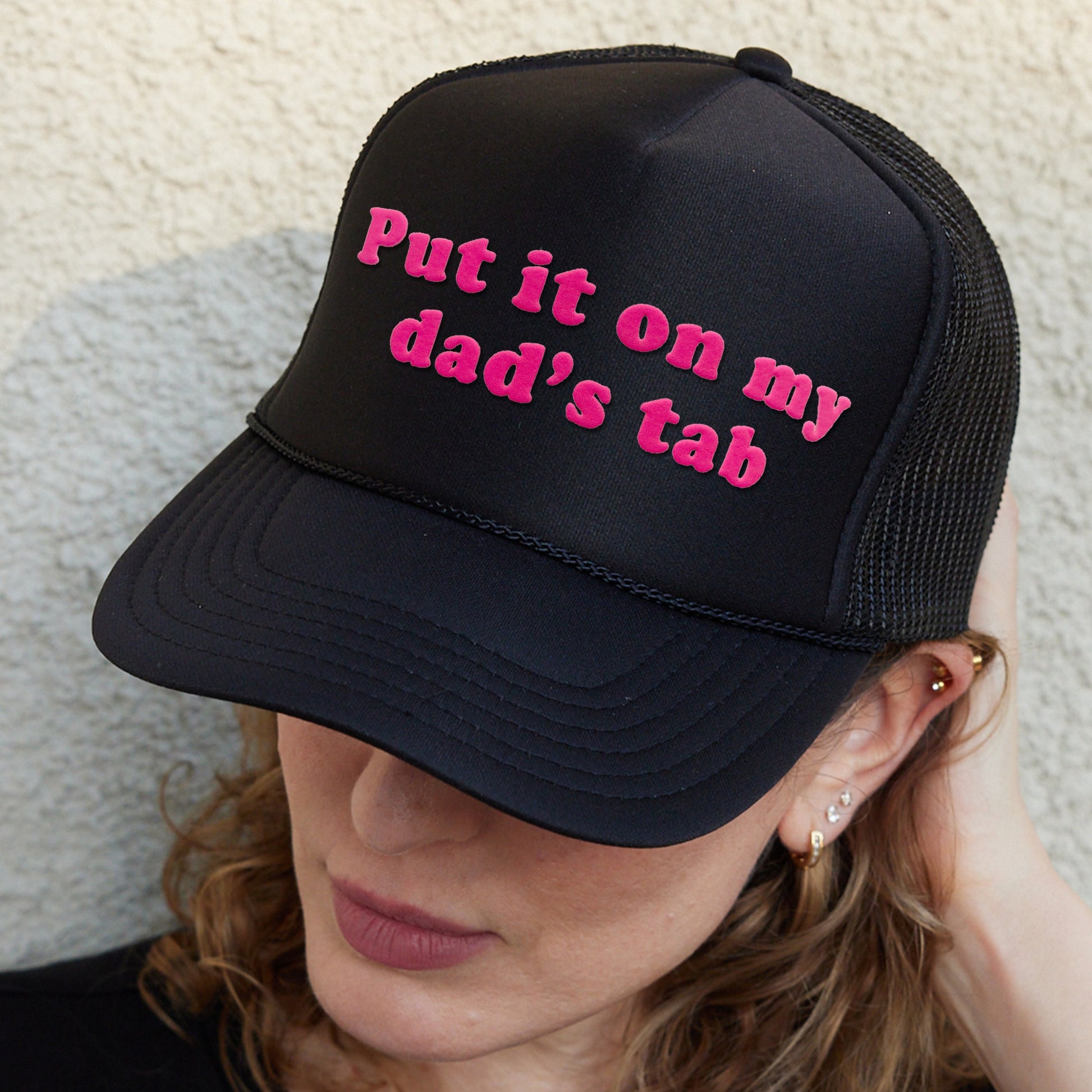 a woman wearing a hat that says put it on my dad&#39;s tab