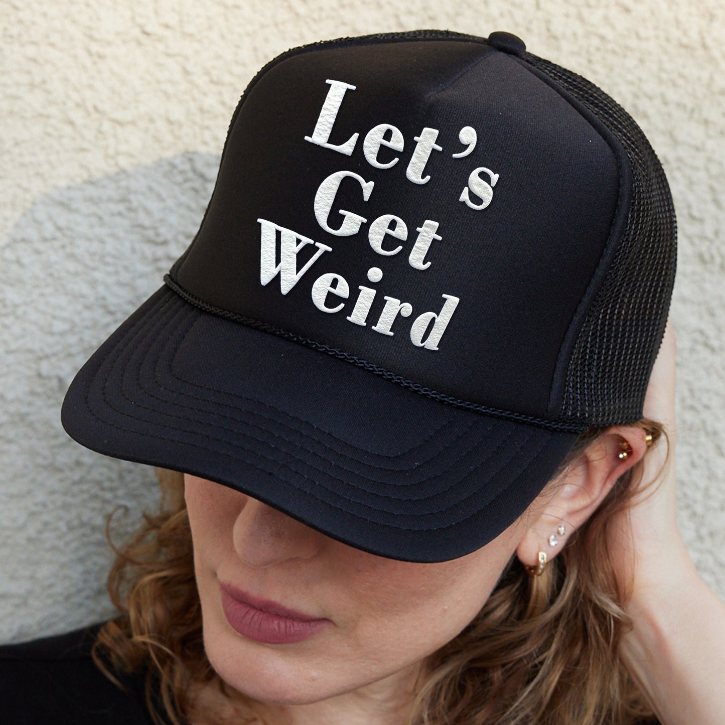a woman wearing a hat that says let&#39;s get weird