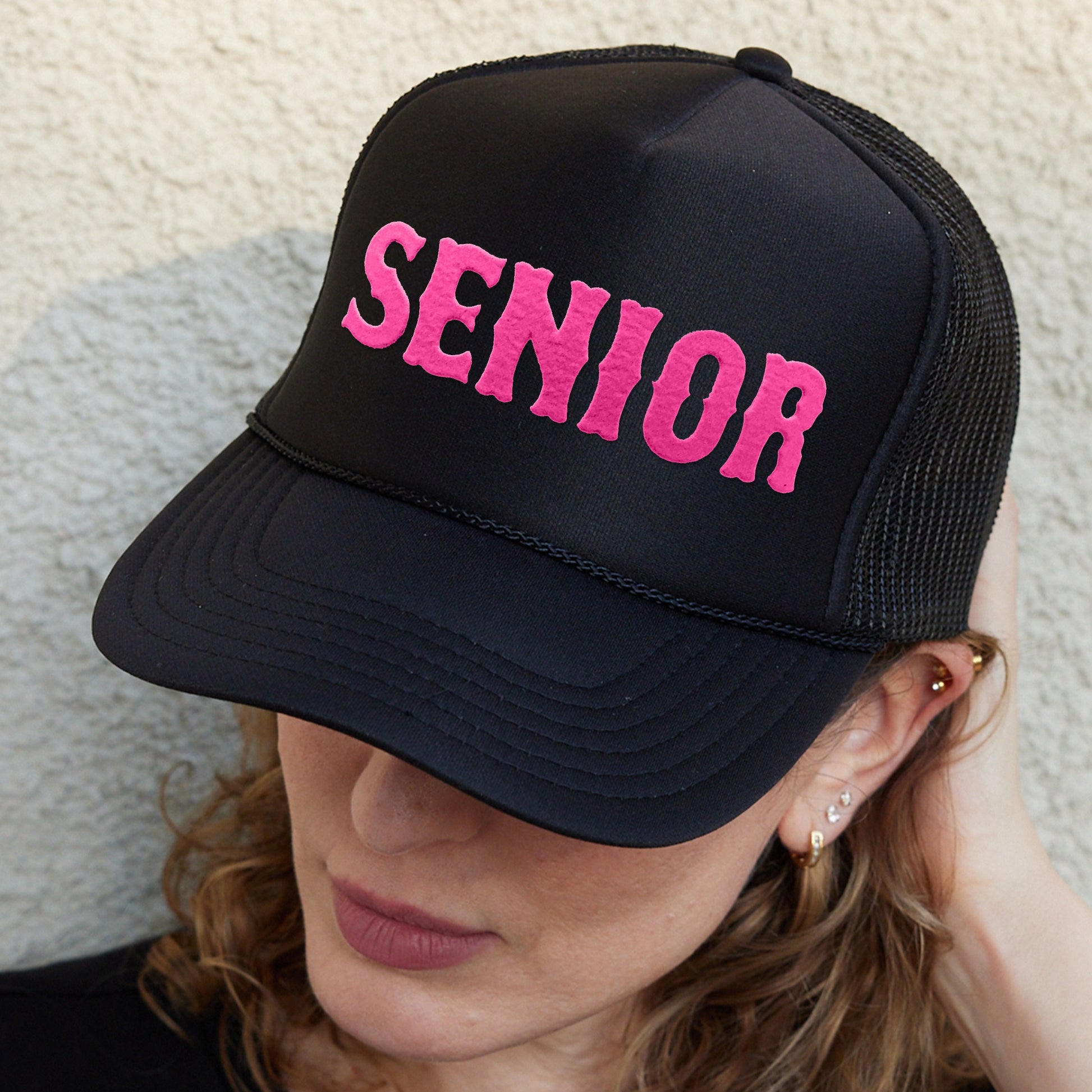 a woman wearing a hat with the word senior on it