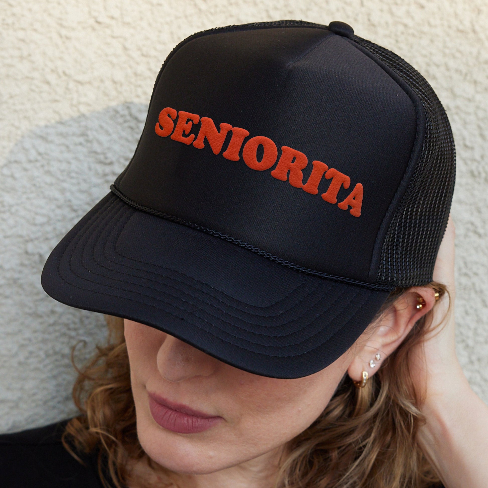 a woman wearing a black hat with the word senioria on it