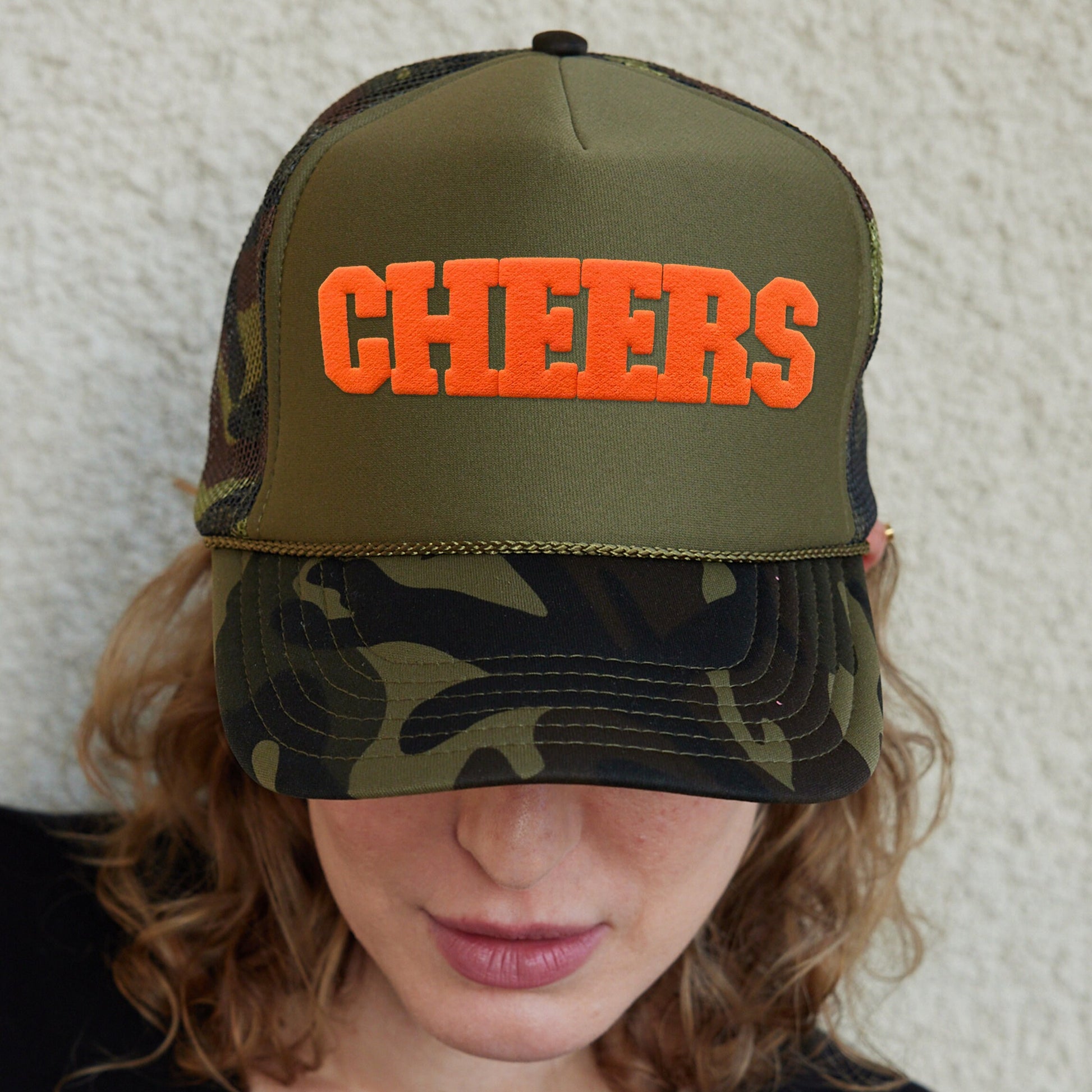 a woman wearing a hat with the word cheers on it
