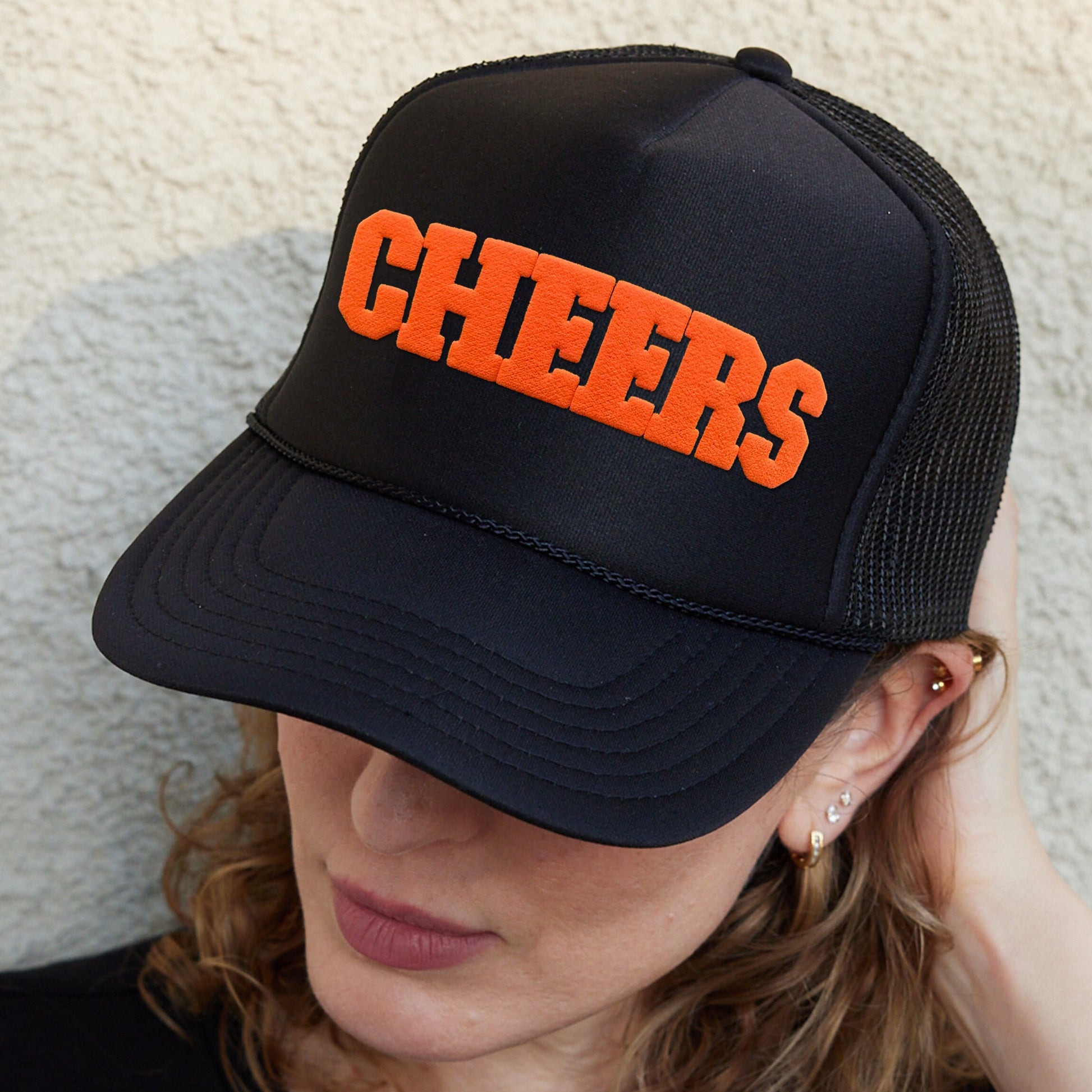 a woman wearing a hat with the word cheers on it
