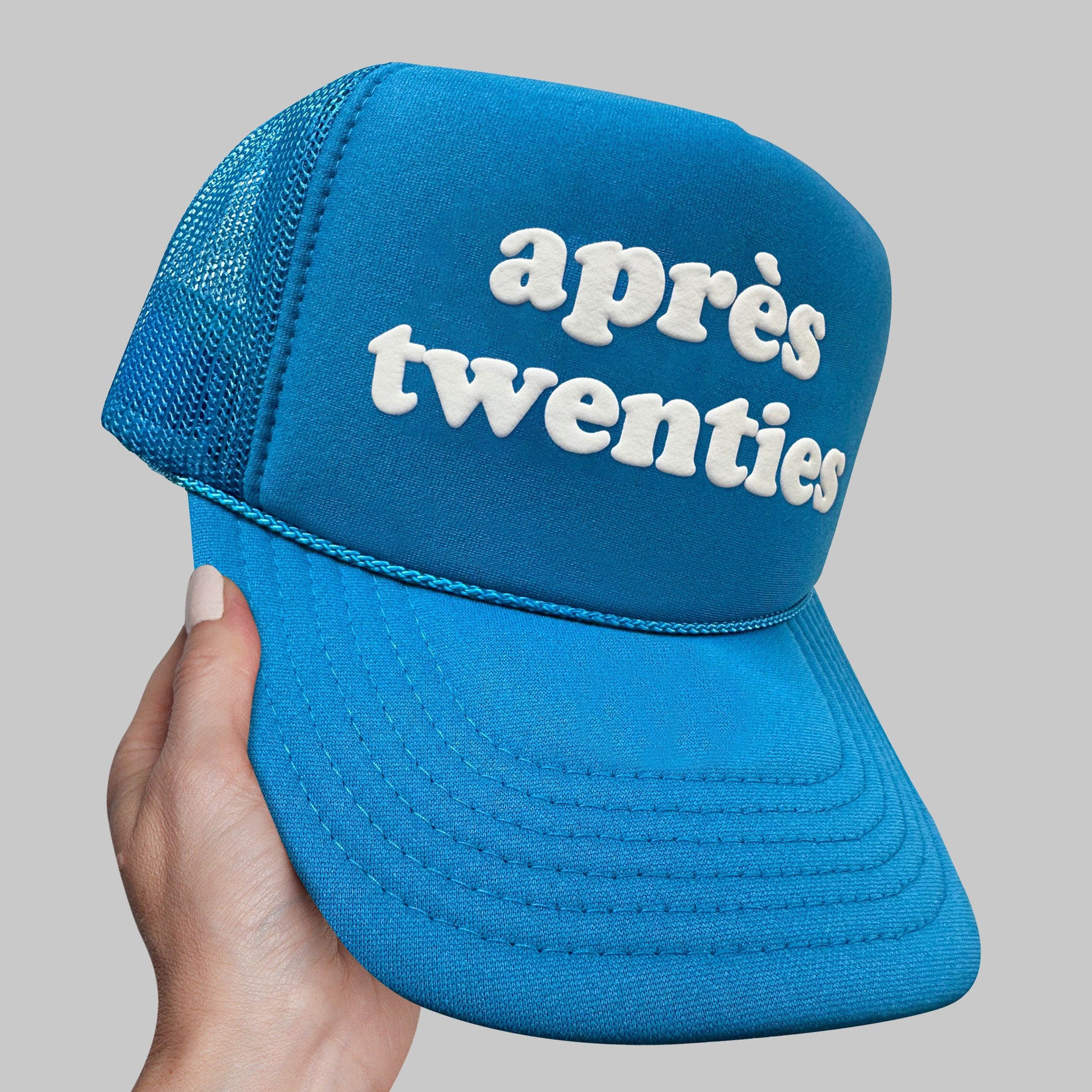 a person holding up a blue hat with the words appre&#39;s twen