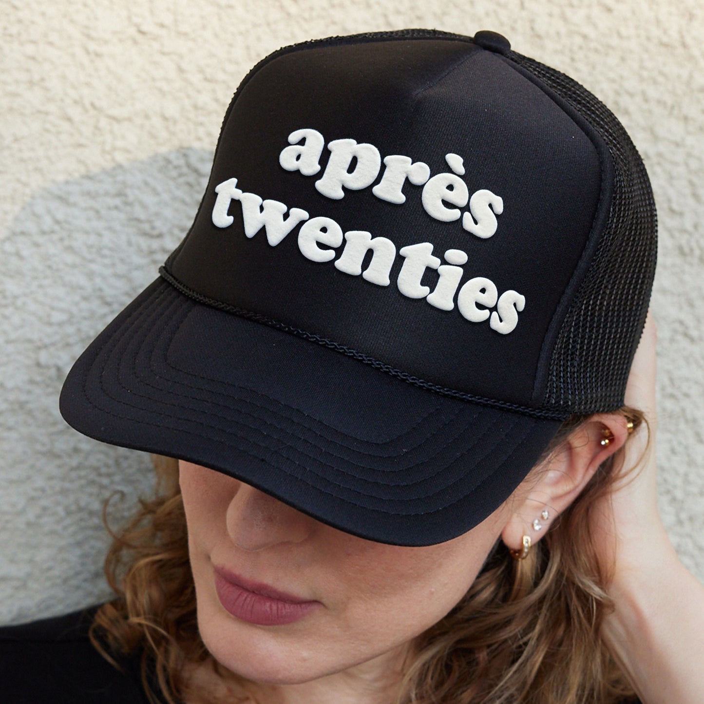 a woman wearing a hat that says apres twenties