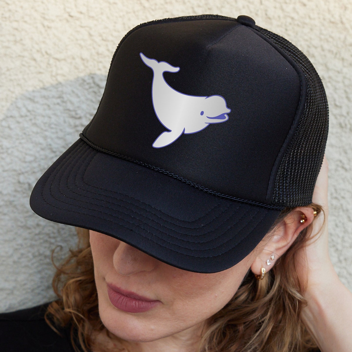a woman wearing a black hat with a white whale on it