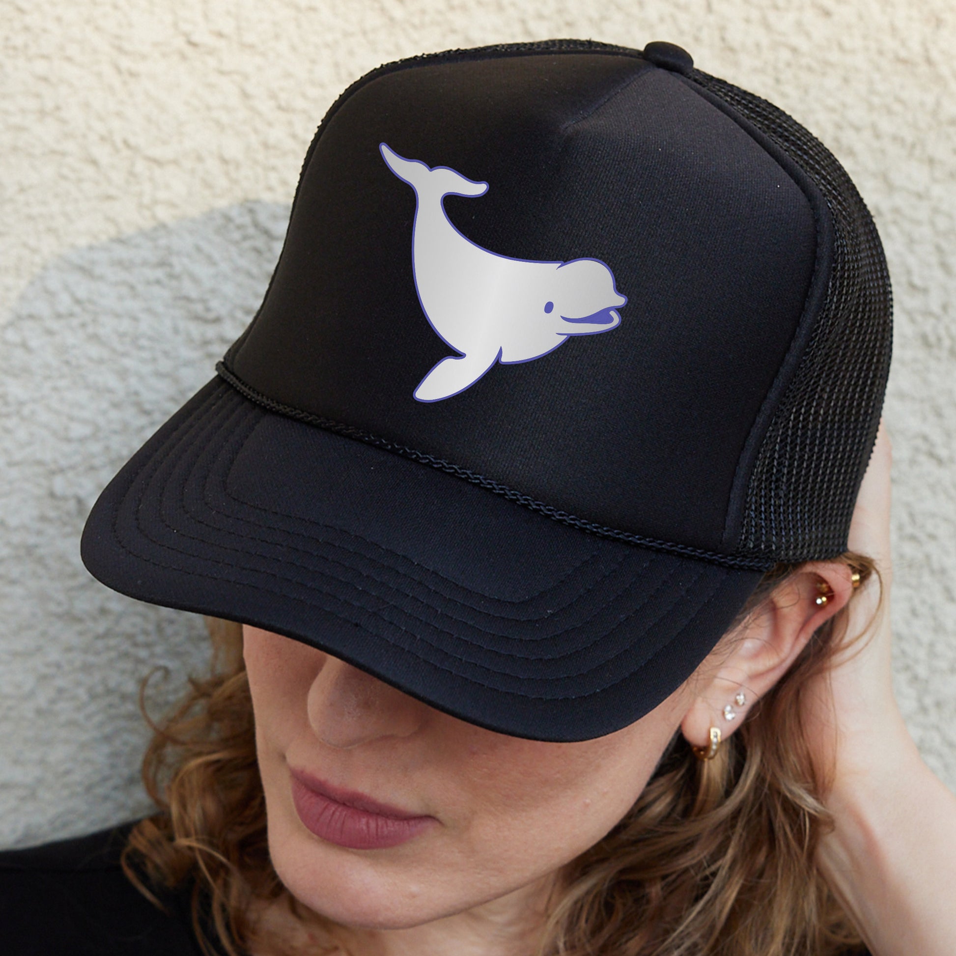 a woman wearing a black hat with a white whale on it