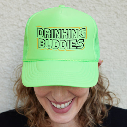 a woman wearing a neon green trucker hat that says drinking buddies