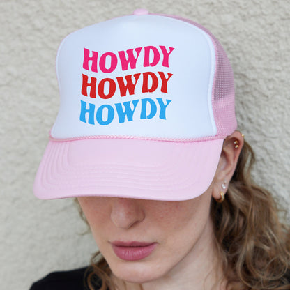 a woman wearing a pink and white trucker hat