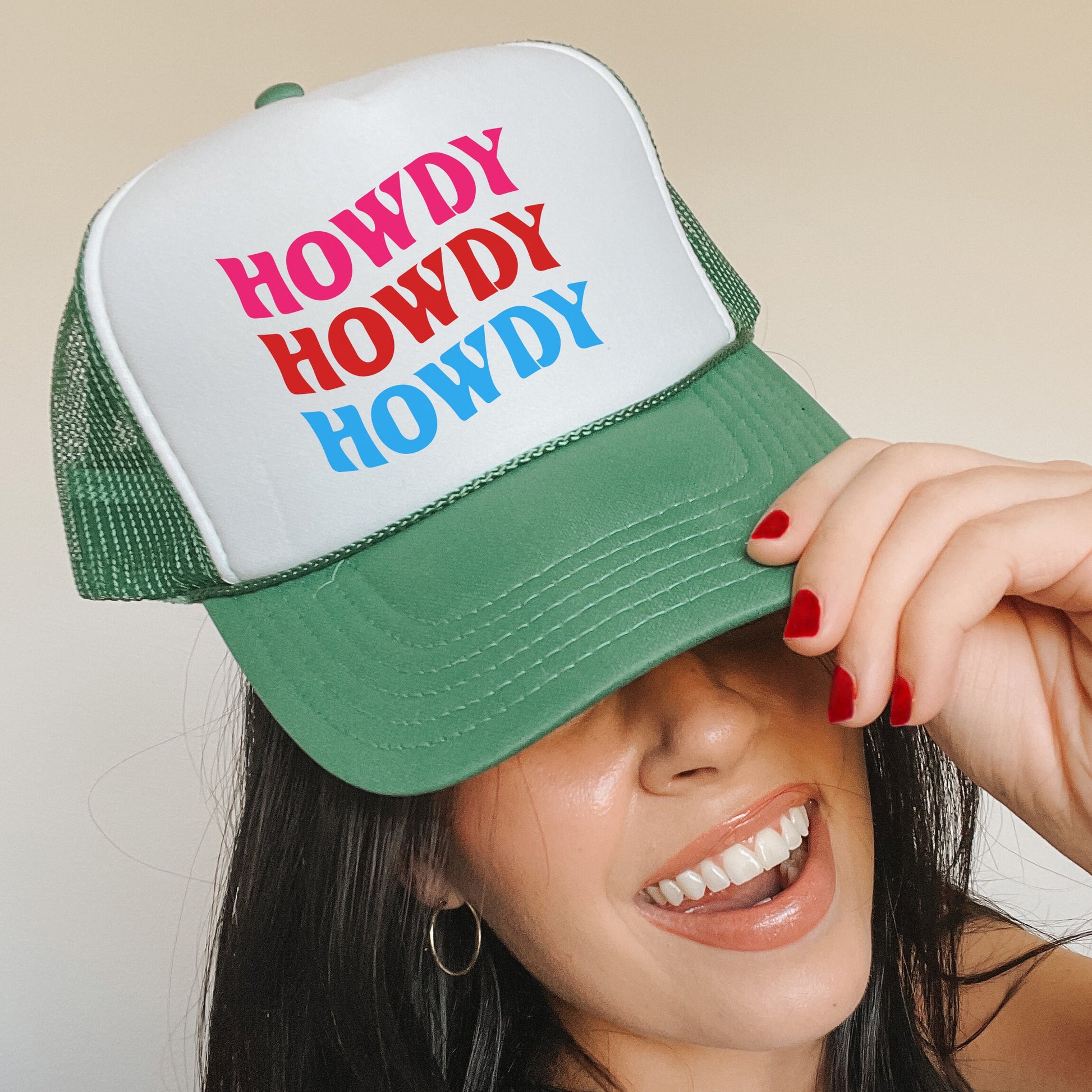 a woman wearing a green and white hat with the words howdy howdy