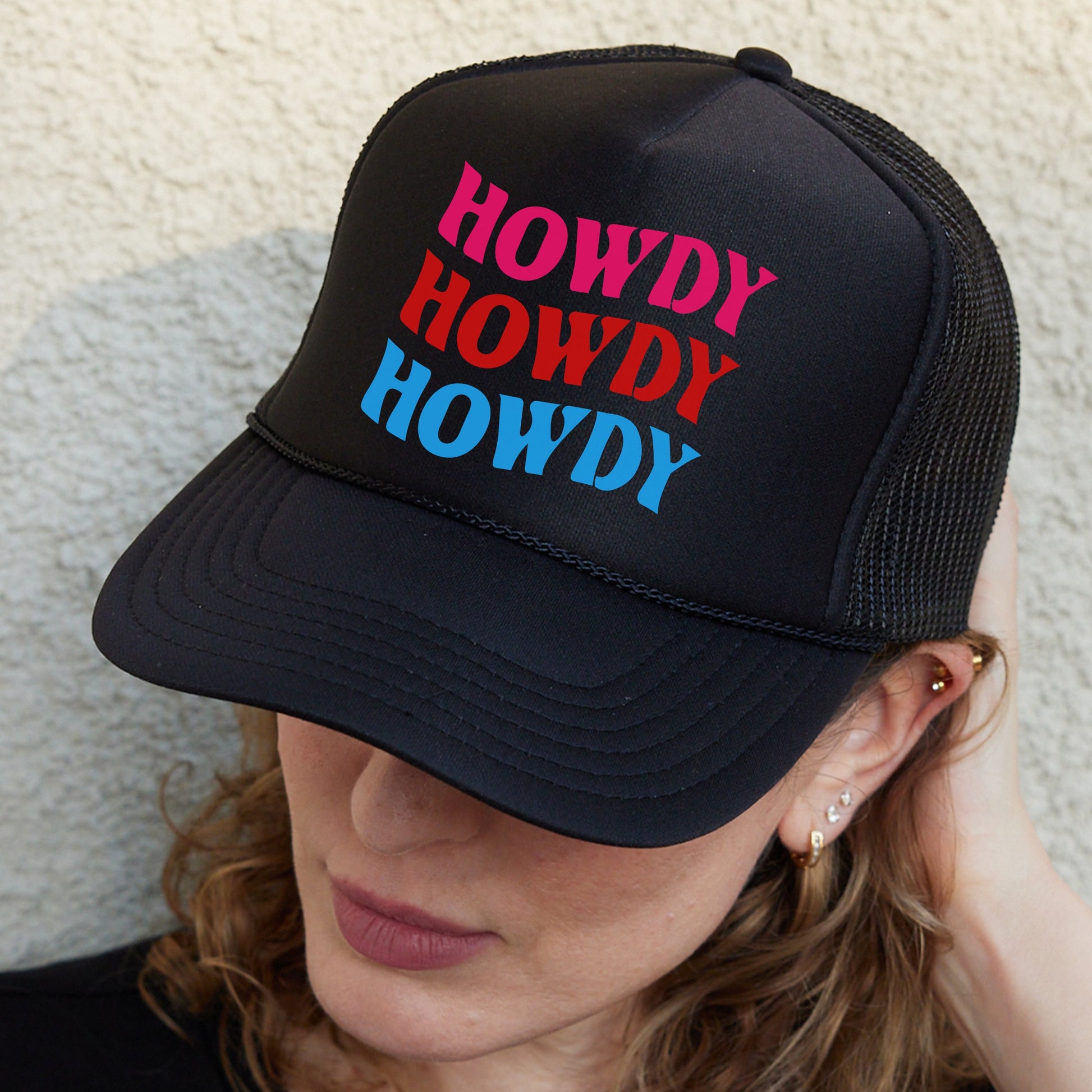 a woman wearing a black hat with the words howdy howdy on it