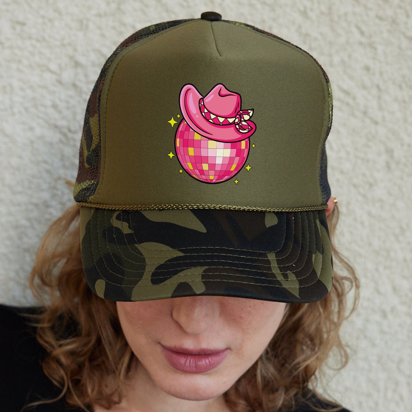 a woman wearing a green hat with a pink pig on it
