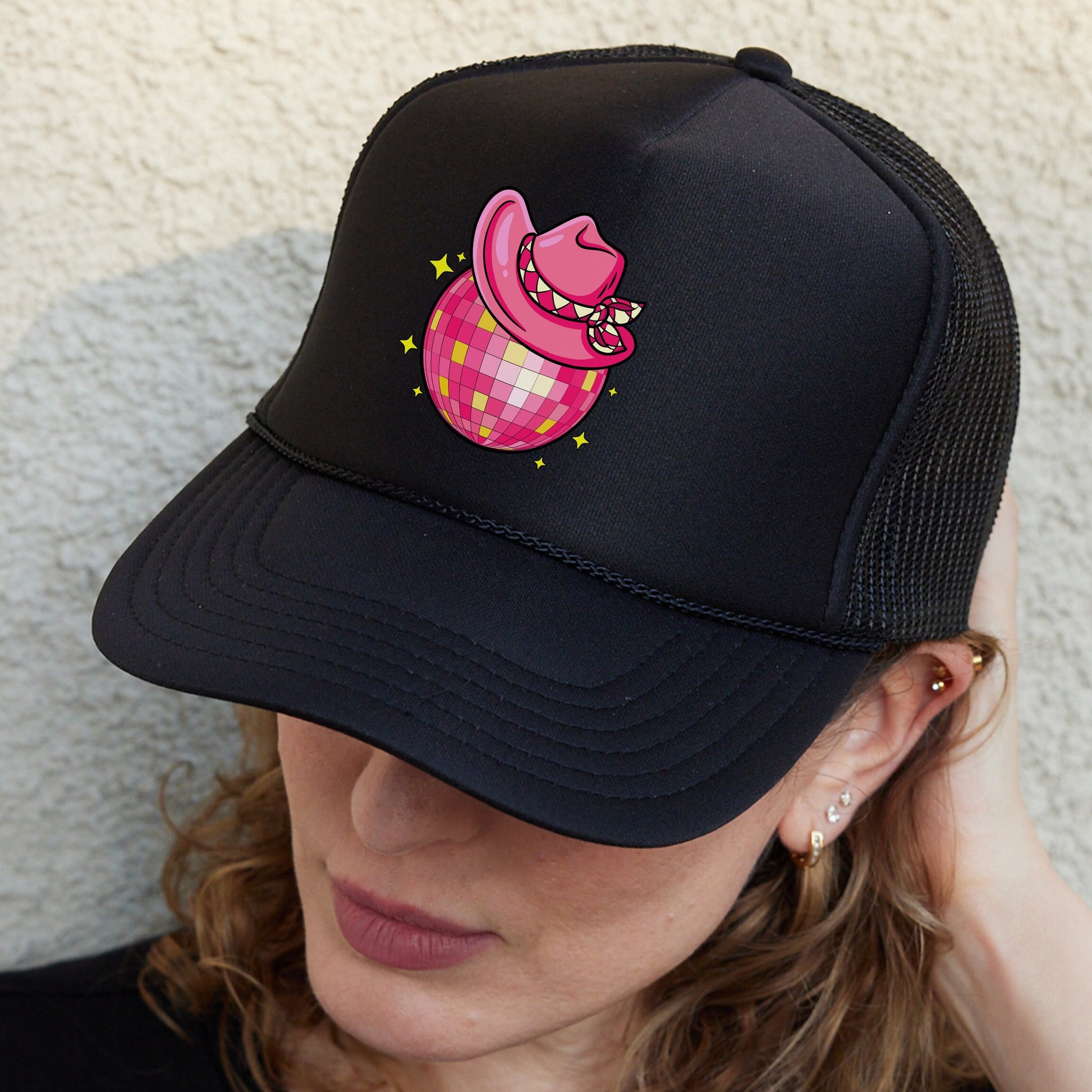 a woman wearing a black hat with a pink pig on it