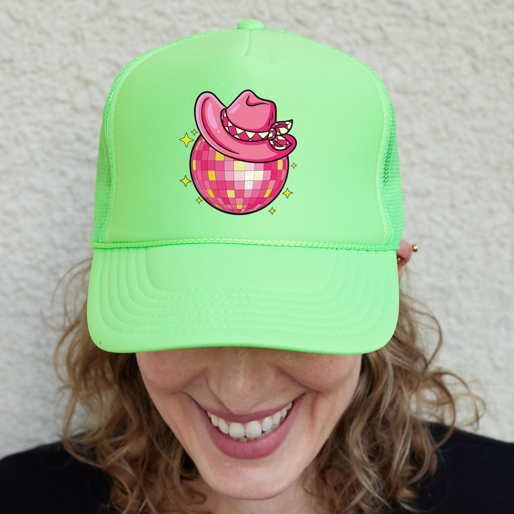 a woman wearing a green hat with a pink pig on it